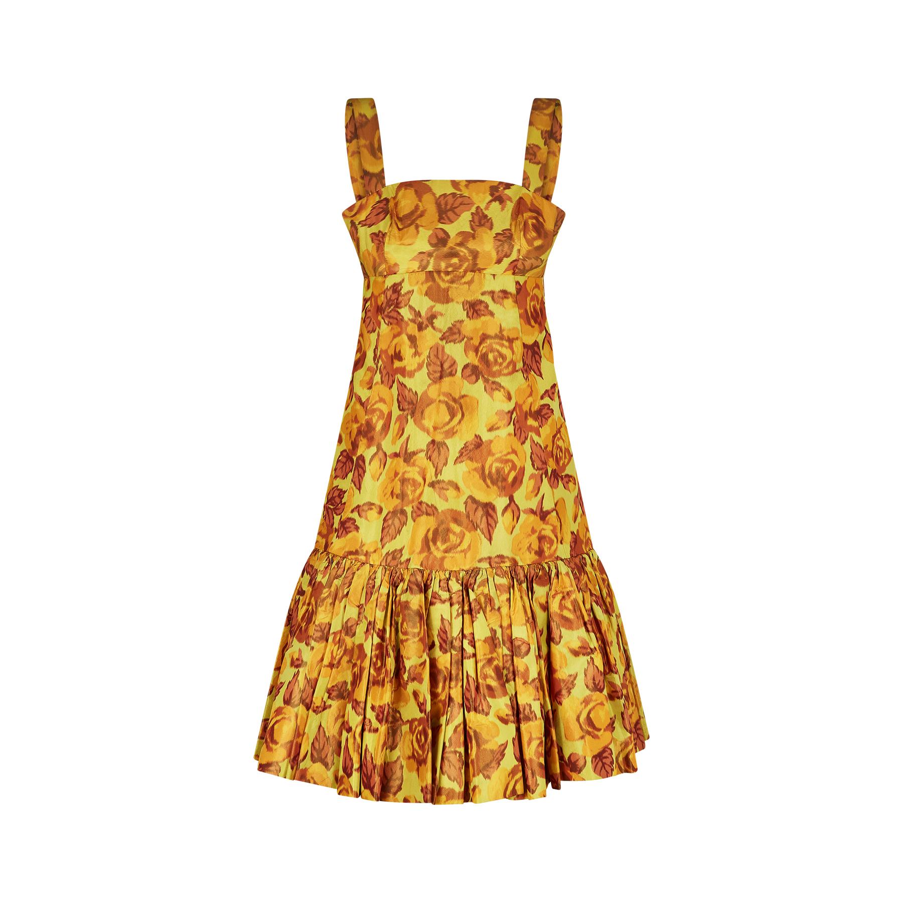 This is a really unusual couture made dress from Traina-Norrell that is almost certainly from the mid to late 1950s. The fabric is a superb silk taffeta in a rose print whilst the colours are chartreuse and earth tones of ochre and orange.  It has