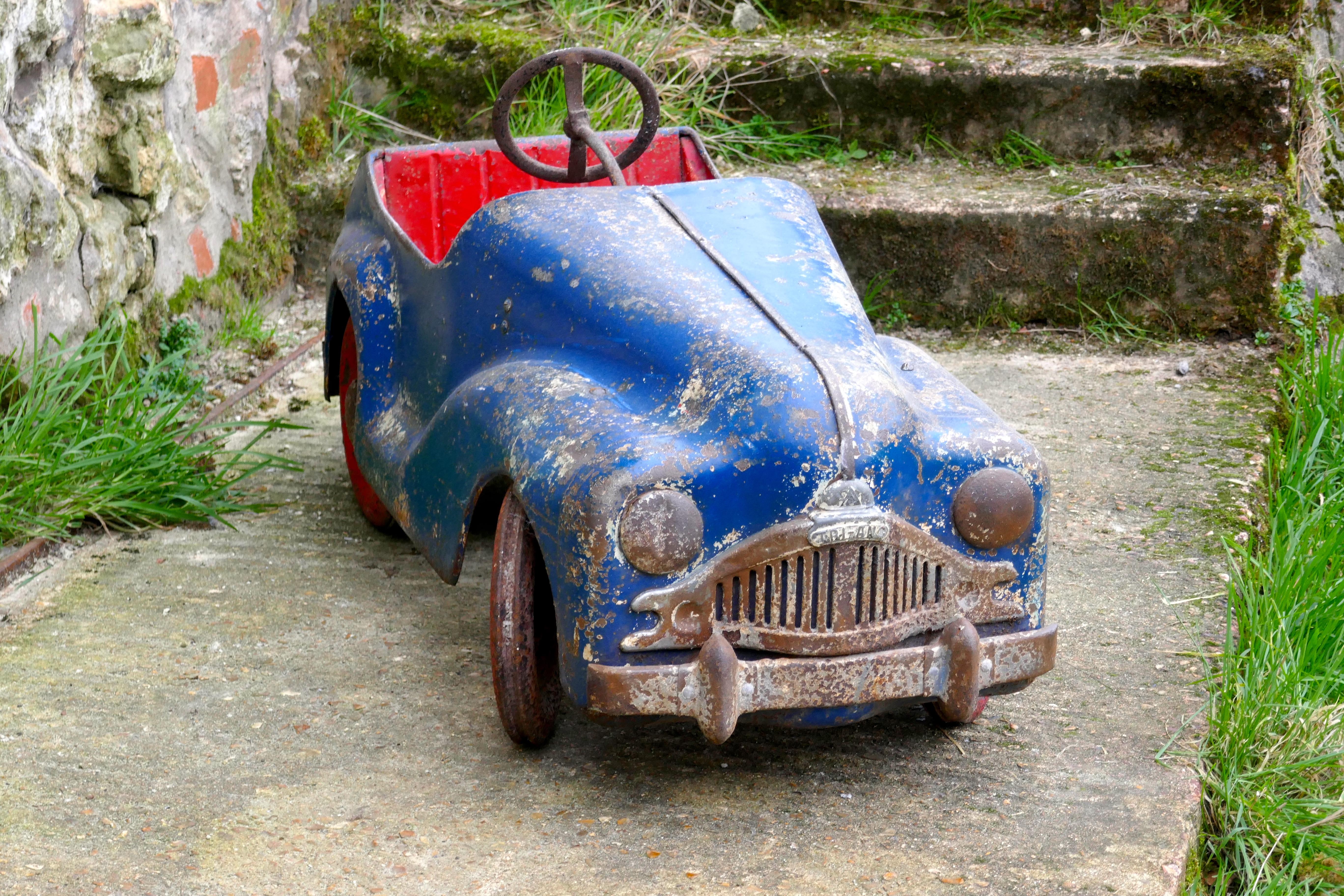 Unrestored 1950s Tri-ang  Pedal Car, Original Paint

A Gem, made in the early 1950s a  Tri-ang pedal car, this one seems to be complete, the only thing that seems to be missing are the rubber tyres. It works of sorts as in the pedals go to and fro