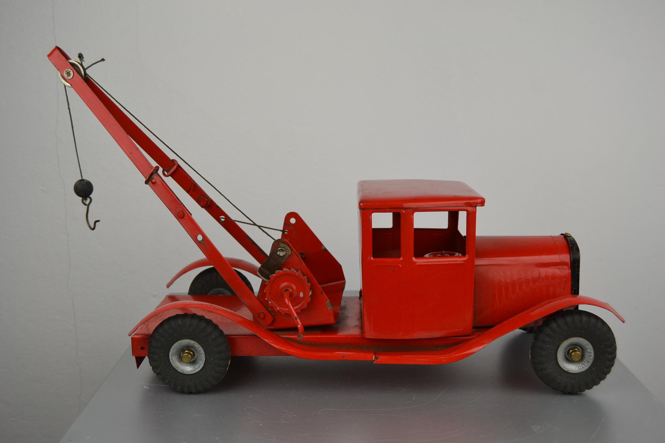 Large vintage pressed steel Bedford lorry wrecker toy truck.
Made by Tri-Ang / Triang between 1948-1957 in England.
The metal Truck has a good straight Body with original red paint, boom ( has some inflection see pics), string and hook. The rubber
