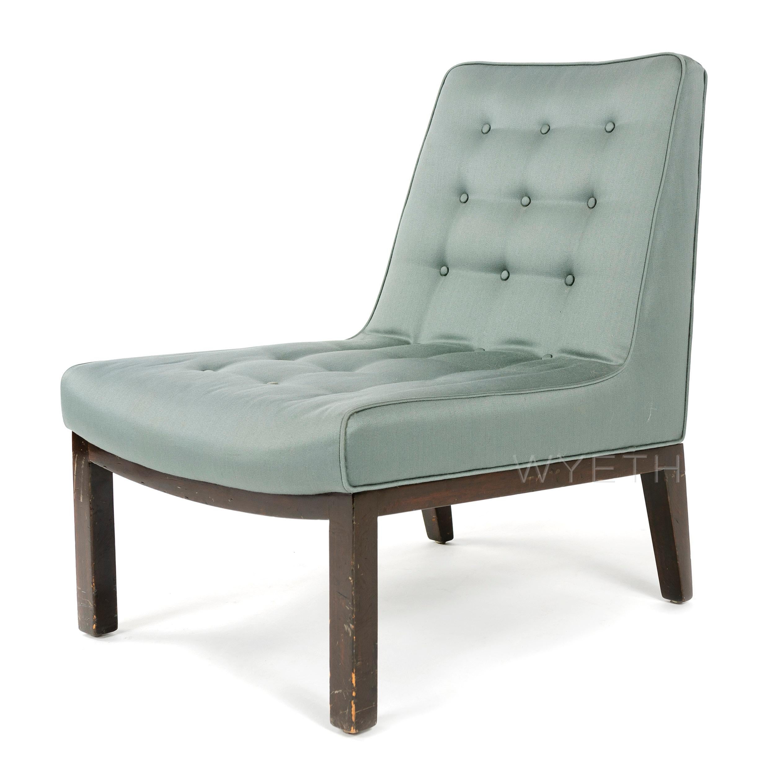 An armless button tufted lounge chair of generous proportion having exposed walnut base. Model: 5000.