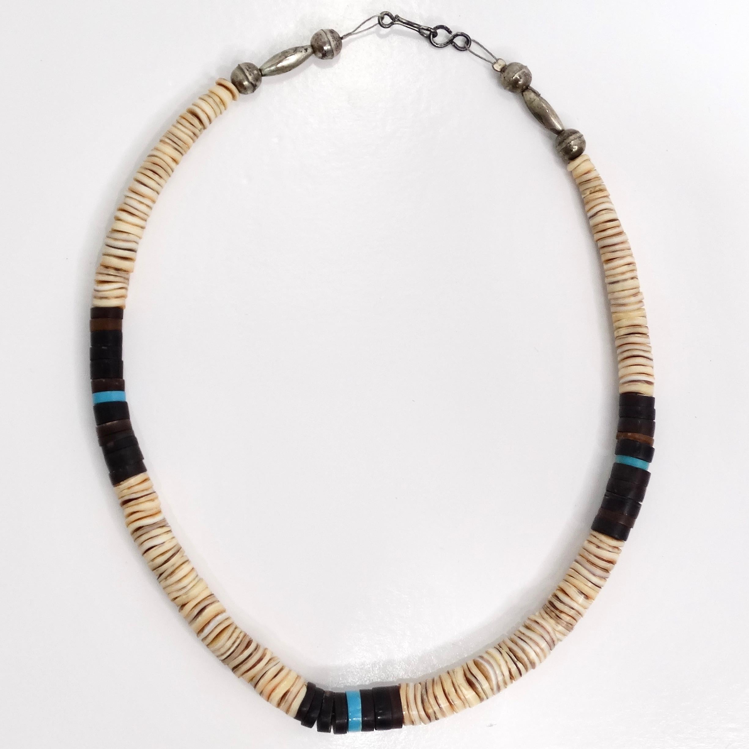 Elevate your vintage jewelry collection with the stunning 1950s Turquoise Shell Beaded Necklace. This exquisite choker features a harmonious blend of vibrant blue turquoise, black, and ivory shell beads, creating a unique and eye-catching design.