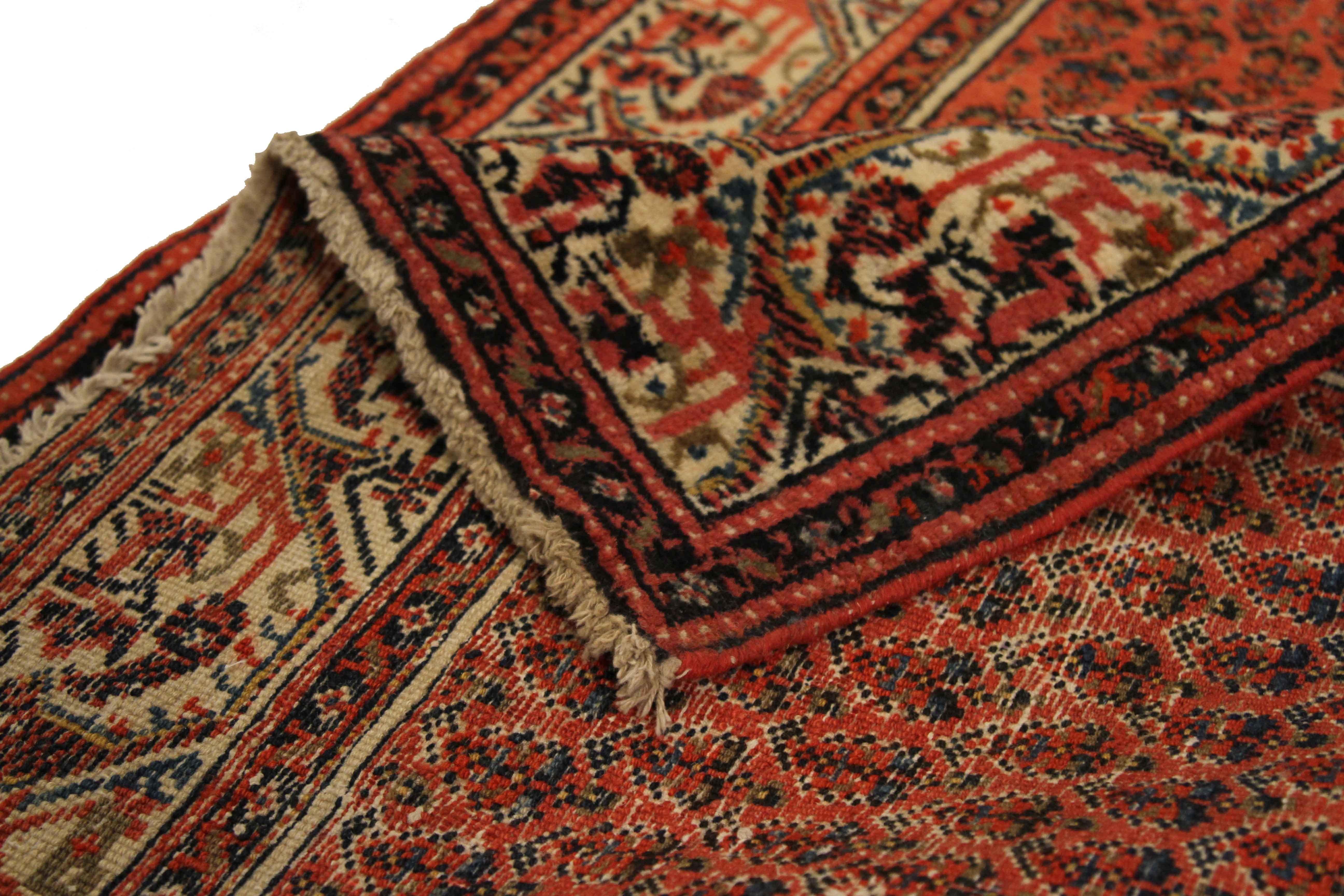 Finely woven by hand using exquisite wool and vibrant vegetable dyes, this antique Persian rug features a wide, open field of ‘boteh’ or leafy patterns popular in Saraband made carpets. Weavers skillfully blended red, black, ivory and blue to make