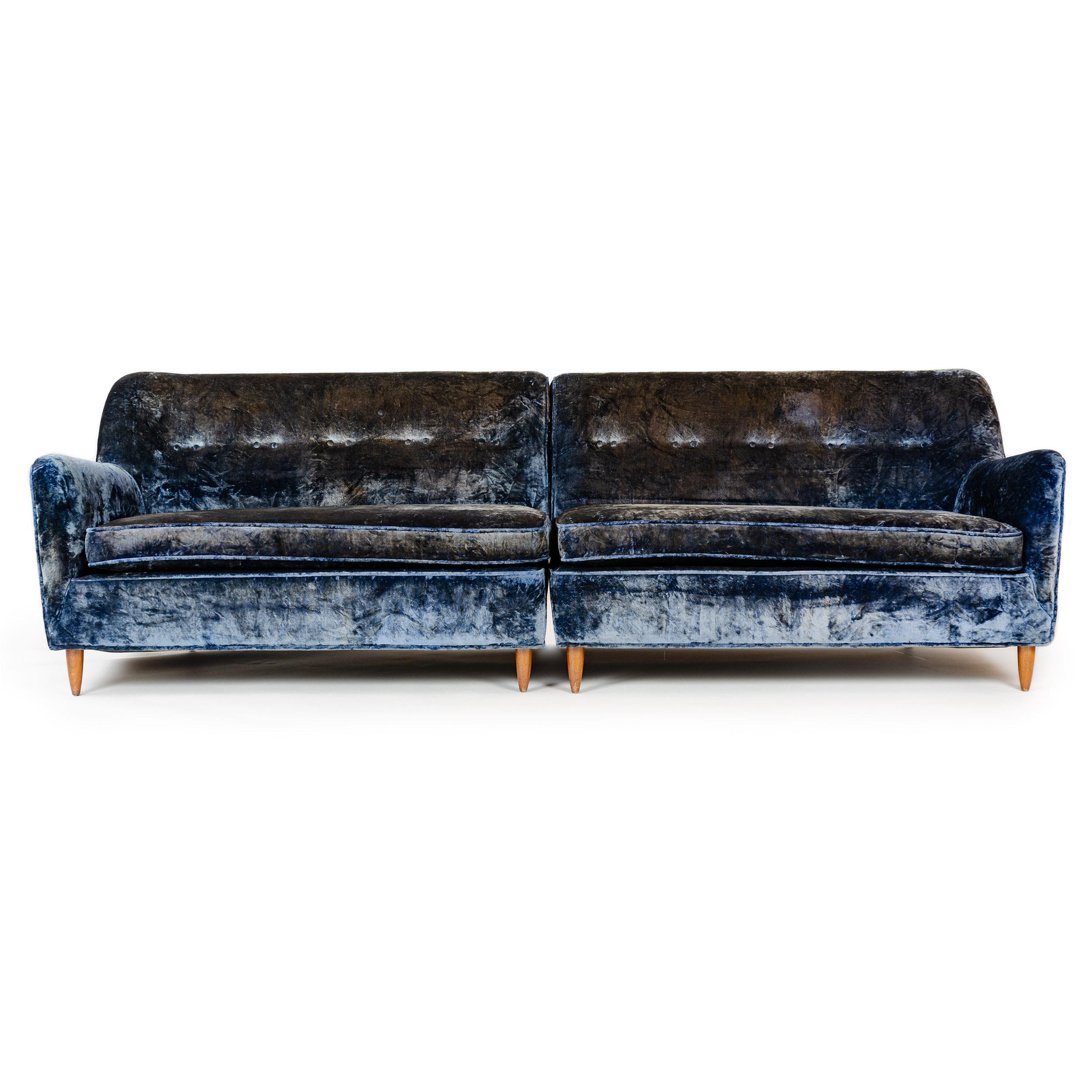 Ein zweiteiliges Sofa aus blauem Samt mit fester Rückenlehne und Originalpolsterung.