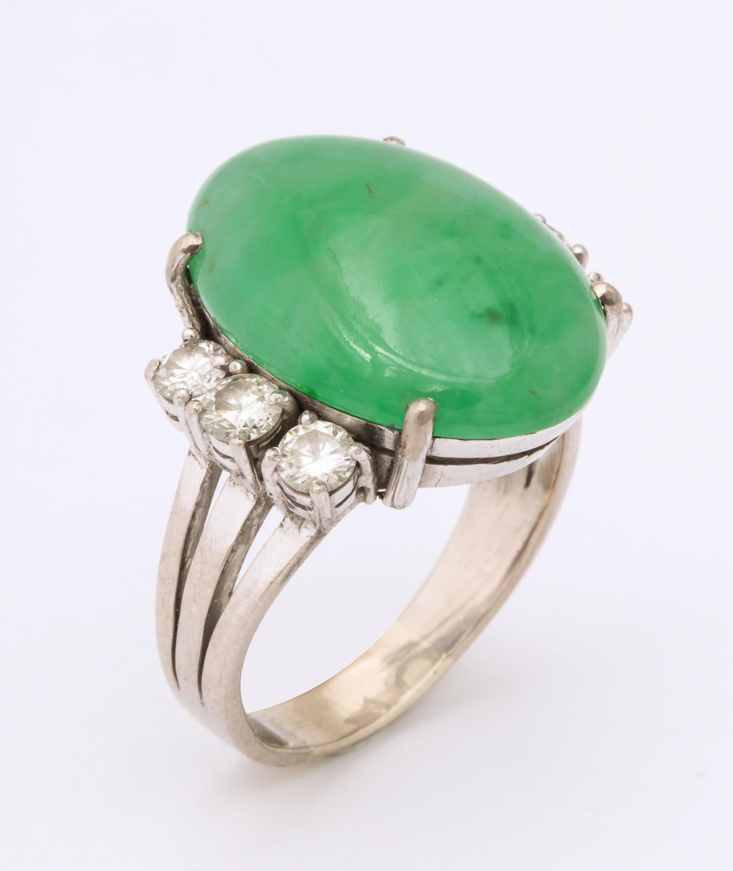 One Elegant Oval Cut Beautiful Color Jadeite Ring Centering A 22MM Oval Jade And Flanked By Six Full Cut Diamonds Weighing Approximately .15 Cts Each ,Total Weight Of Diamonds .90Cts. Created In Platinum,Palladium And 18kt White Gold Shank.