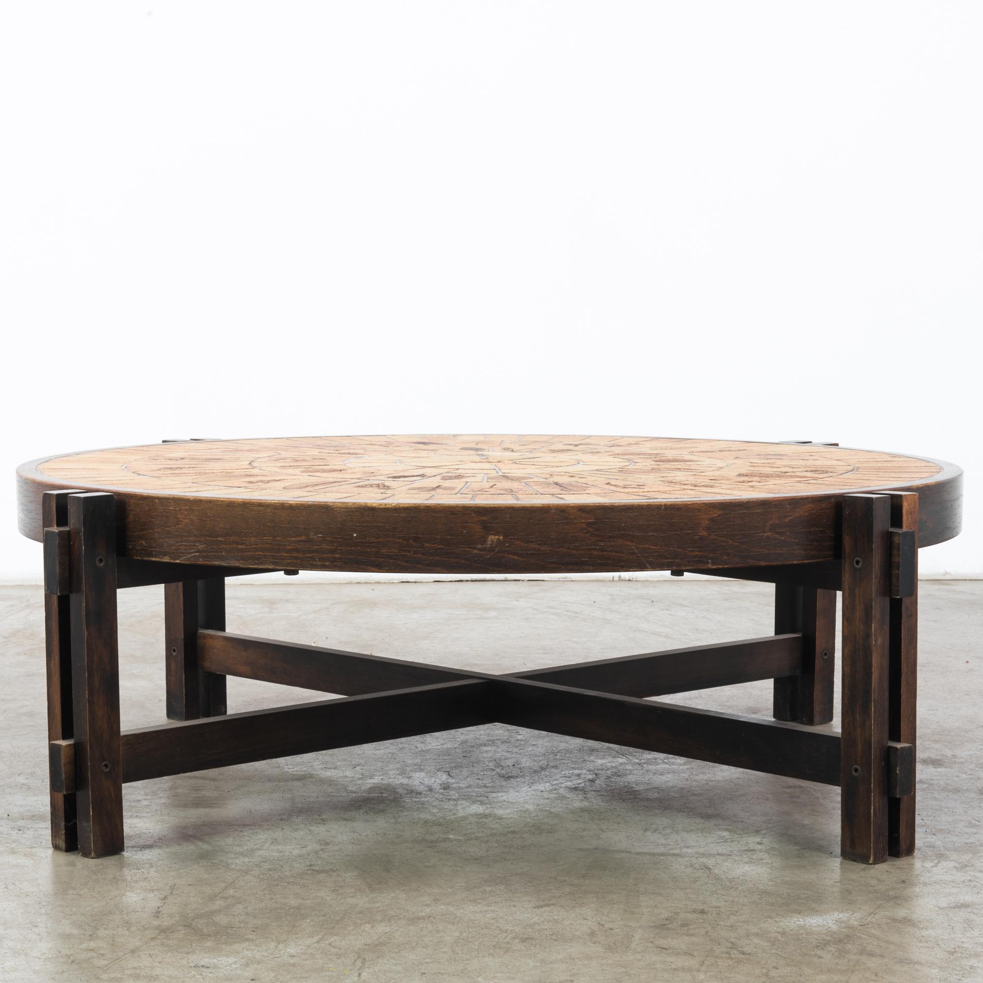 This wooden coffee table was made in France, circa 1950. It was designed by Roger Capron, an artist pivotal in the renaissance of the pottery industry in Vallauris, southeastern France. The circular ceramic top supported on four solid posts features