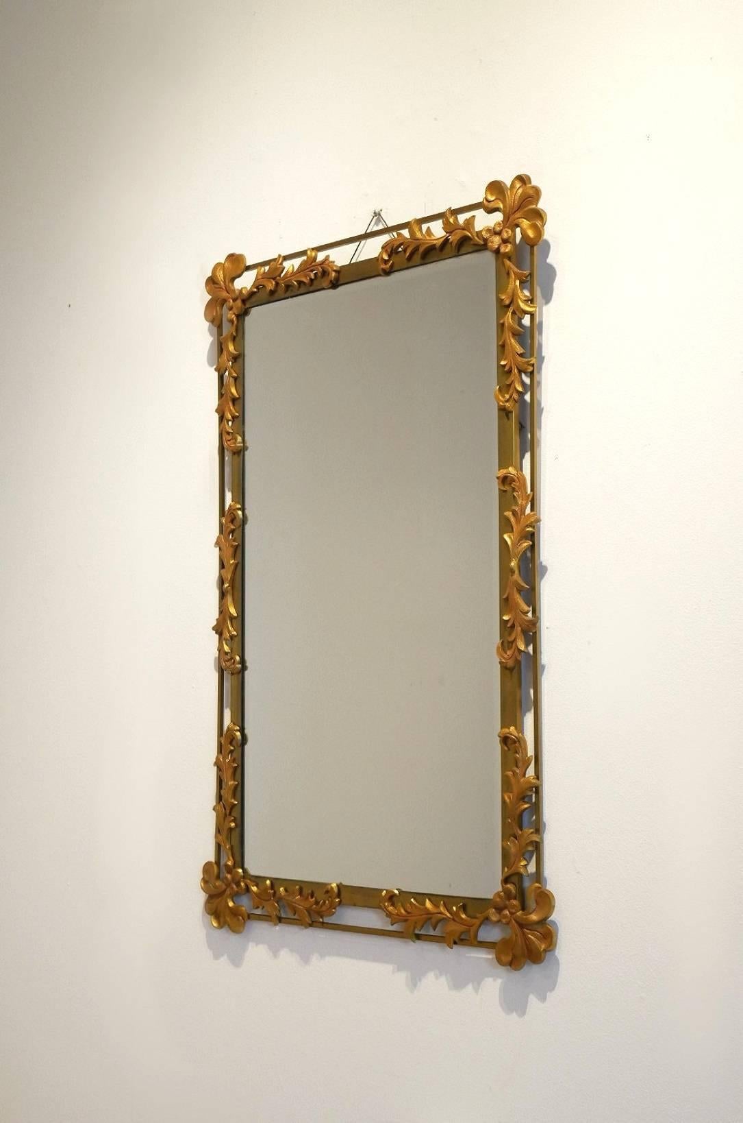 Decorative 1950s wall-mounted mirror, bicolor gilded and painted metal structure with vegetal decor.