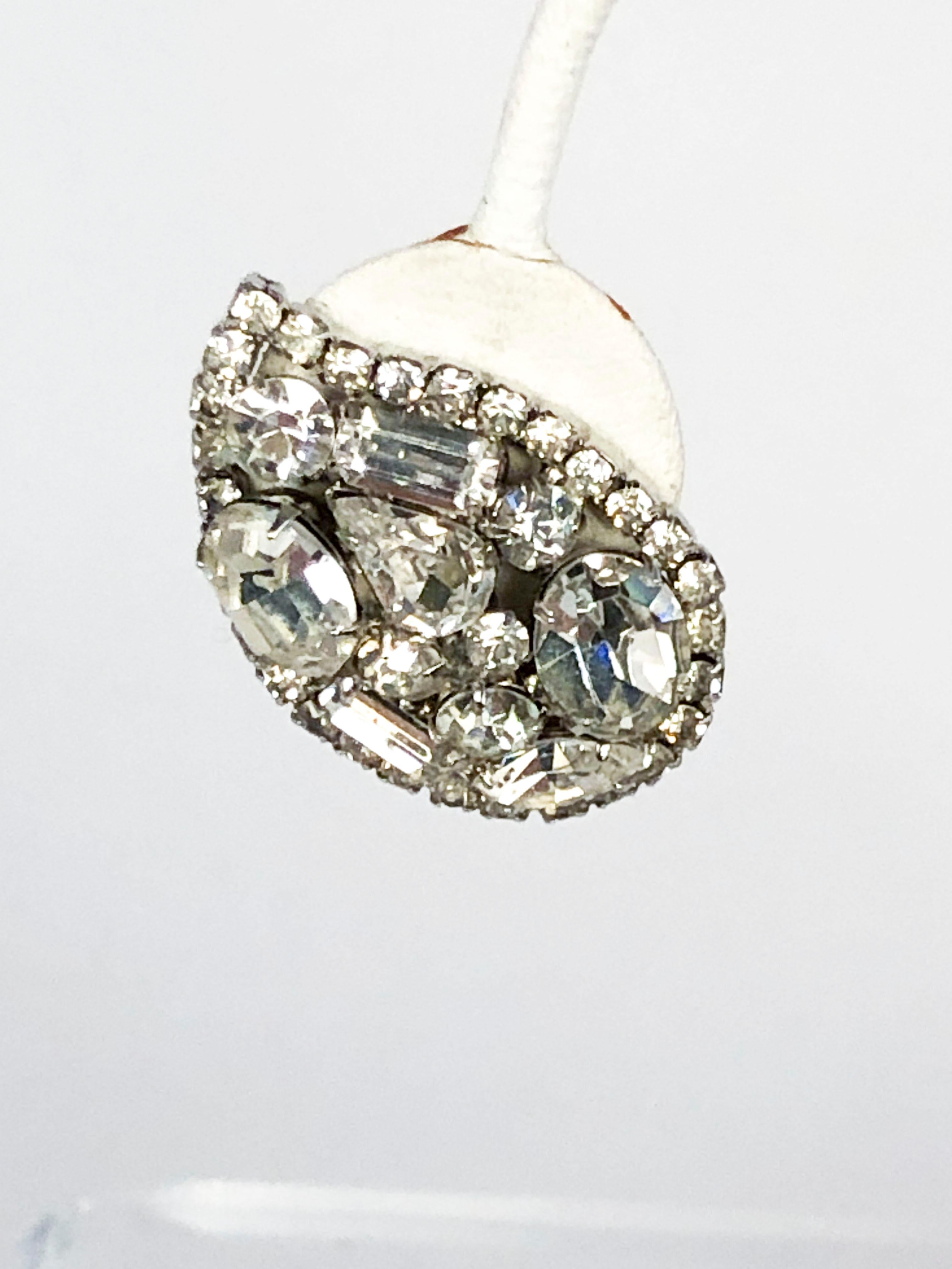 1950s Vendome clip-on earrings with multi-cut/multi-sized clear rhinestones set in a setting metal with a silver wash. The Rhinestones are configured into a teardrop shape to accentuate the shape of the ear. The clips have a screw to adjust the