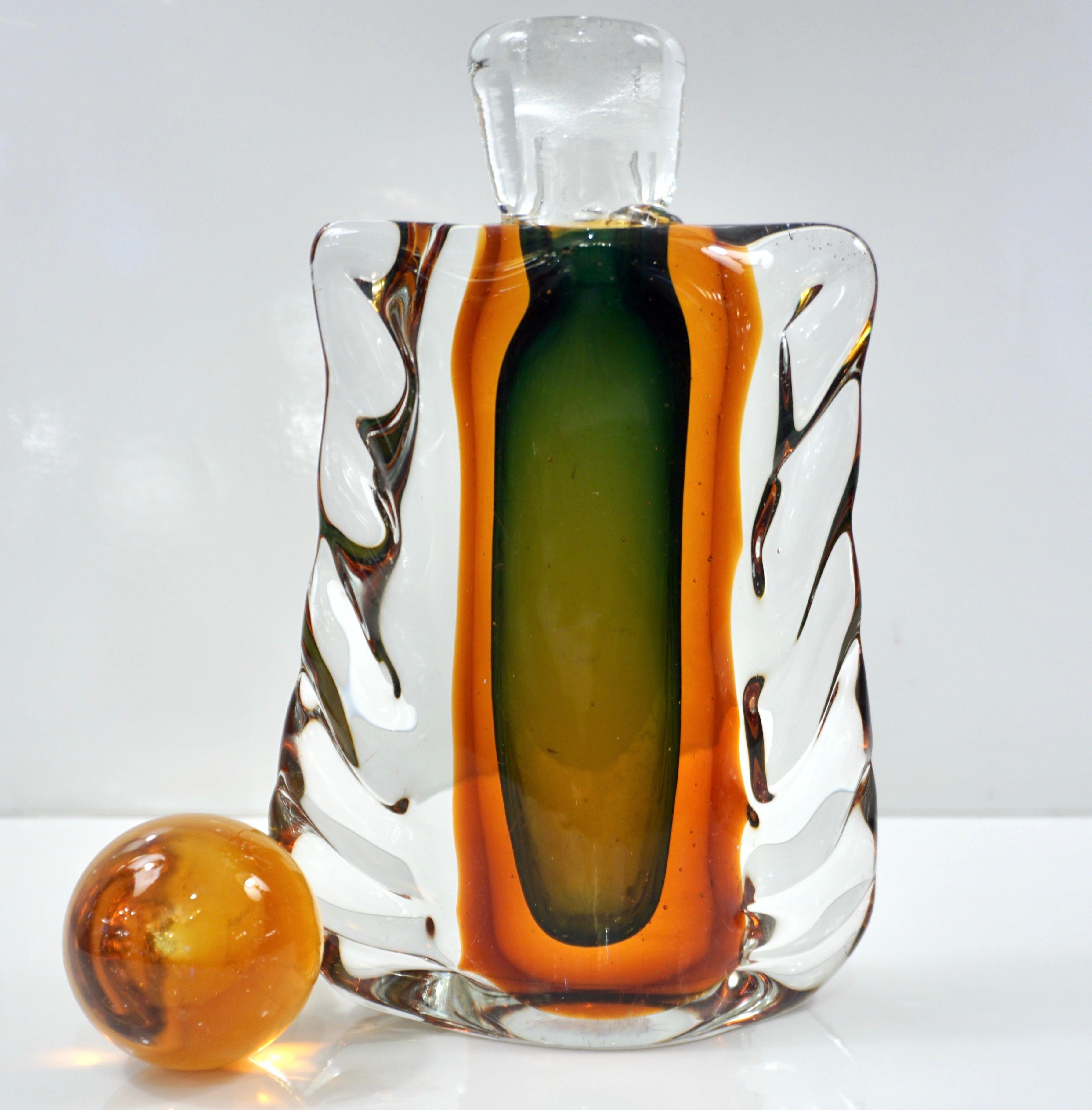 A mid-20th-century rare Venitian bottle with orange solid stopper in Murano glass by Venini, with old paper label, beautiful and sophisticated Venetian work with the Sommerso technique, the green central body completely encased with an orange color