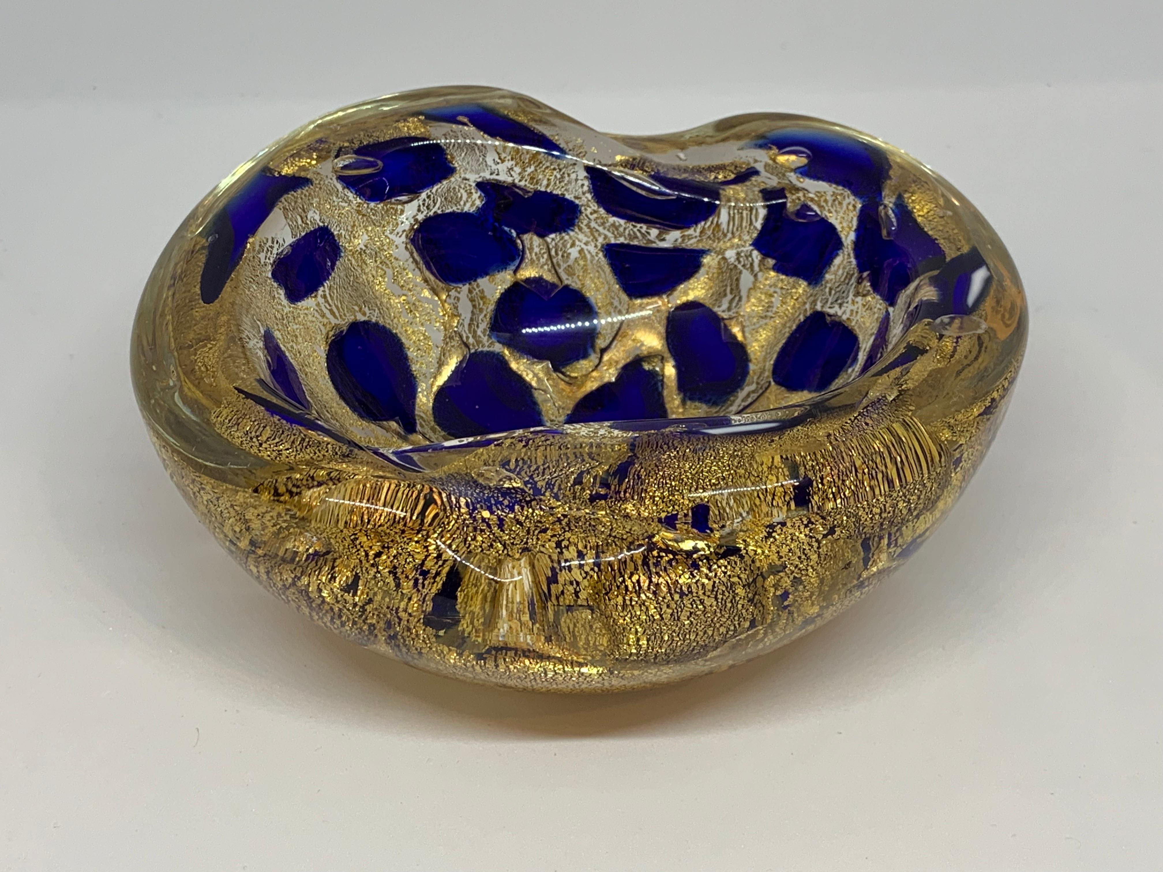 1950s Italian vibrant cobalt blue and gold Murano glass ashtray or bowl by Barovier and Toso. A stunning piece with gold infusions set in clear glass. The bowl has two indentations in each side along the circumference. There are two white glass