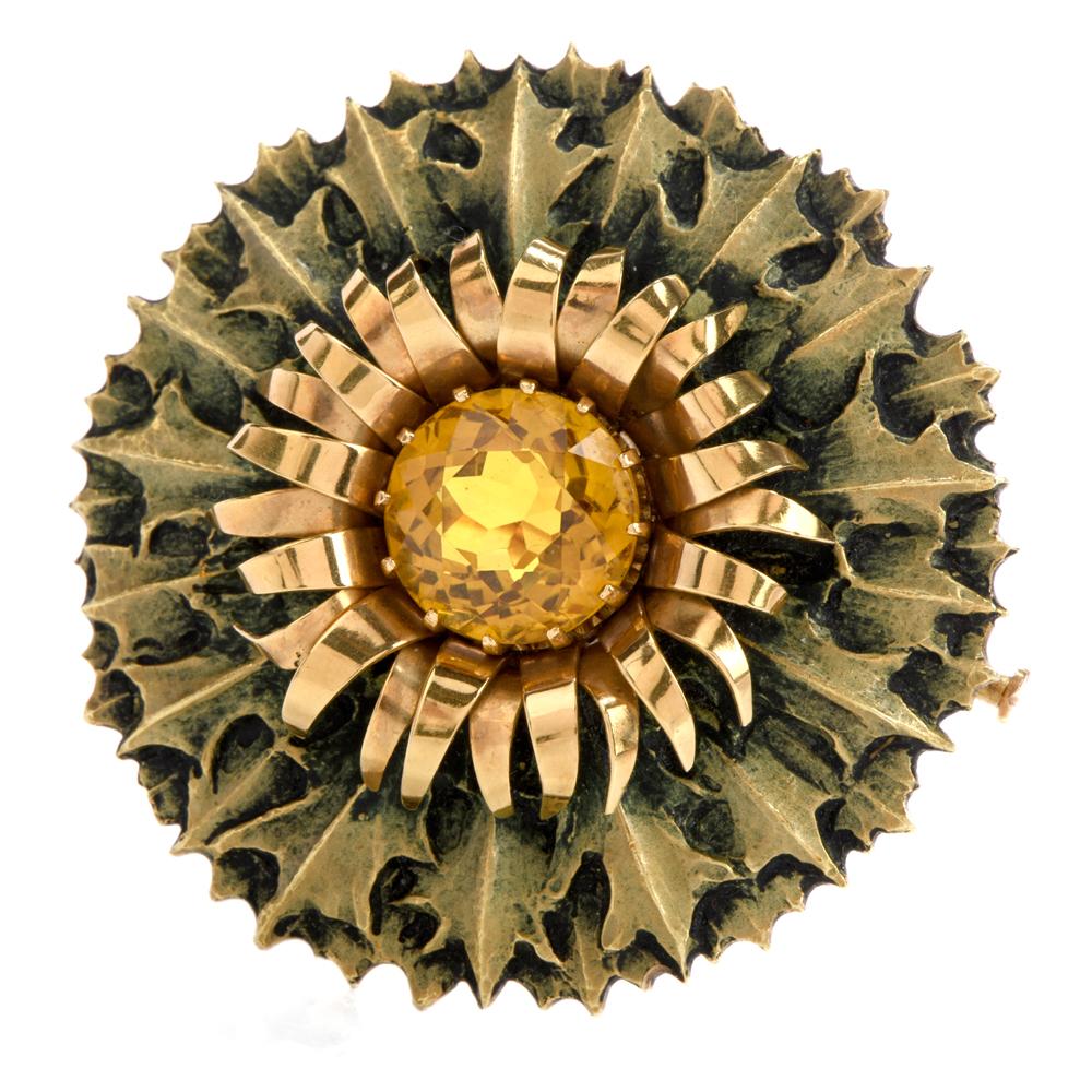 This vintage 1950s brooch was inspired in a Art Nouveau floral 

motif and crafted in 18K yellow gold.

Adorning the center of this 2 layered flower is a vibrant orangy-yellow round, 

faceted Citrine weighing approximately 8 carats.

The inside