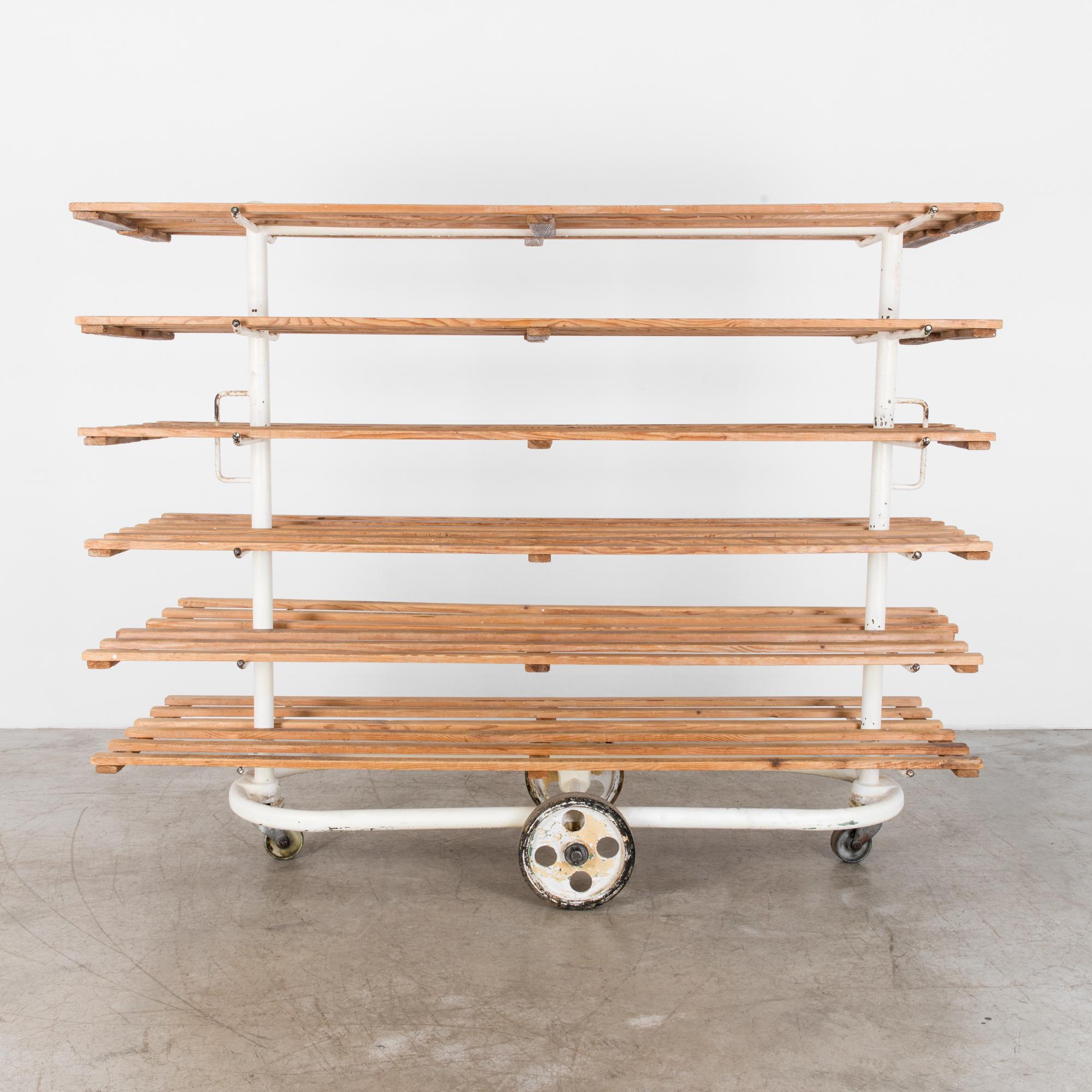 Rustic bread cart from Czechia, circa 1950 with six shelves. The practical steel frame is enamelled in white, alongside naturally finished wooden shelves for a bright and contemporary effect. A white geometric frame in tubular steel contrasts the
