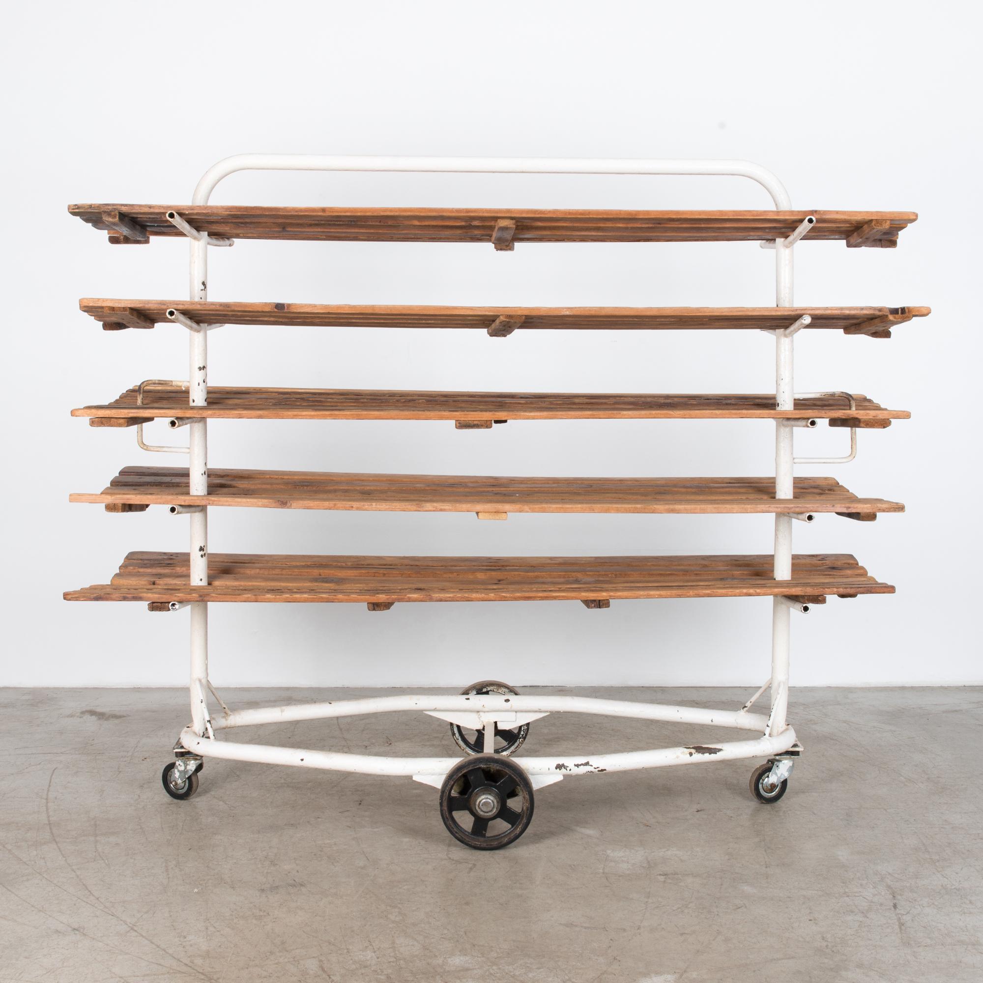 Rustic bread cart from Czechia, circa 1950 with five shelves. The practical steel frame is enamelled in white, alongside naturally finished wooden shelves for a bright and contemporary effect. A white geometric frame in tubular steel contrasts the