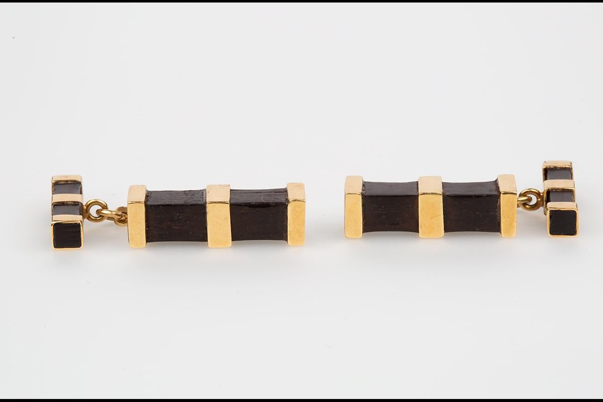 A Vintage pair of double sided cufflinks with batons of bog oak (a type of wood) in two sizes mounted in 18 karat yellow gold. Stamped 750 for 18 karat gold on the connecting bars. The connecting bars are typical of 1950's design.
Larger baton
