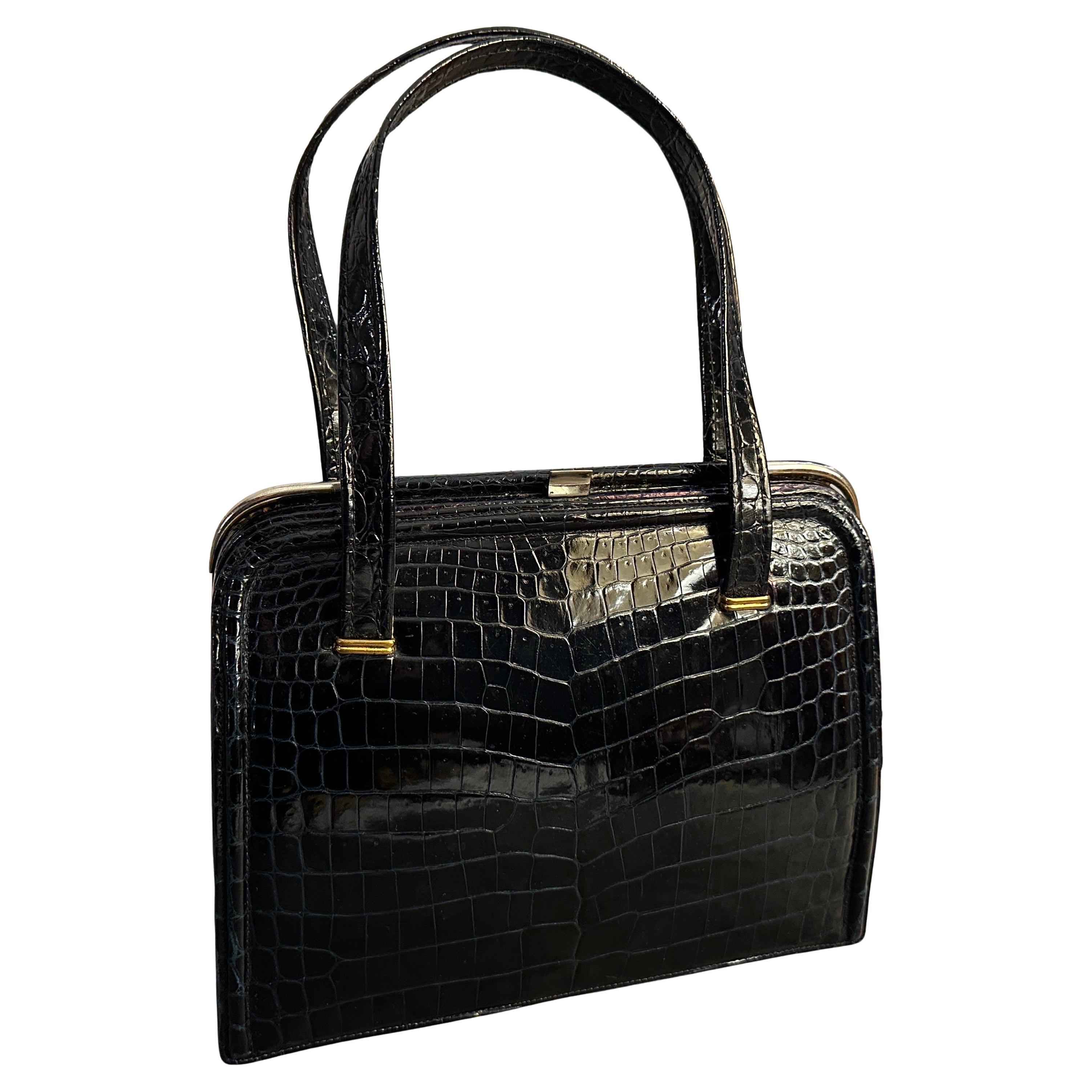 Versetzen Sie sich mit dieser exquisiten und unglaublich schicken Vintage-Tasche mit oberem Henkel aus den 1950er Jahren in eine andere Zeit zurück - ein wahres Zeugnis zeitloser italienischer Handwerkskunst. Diese elegante Handtasche aus schwarzem