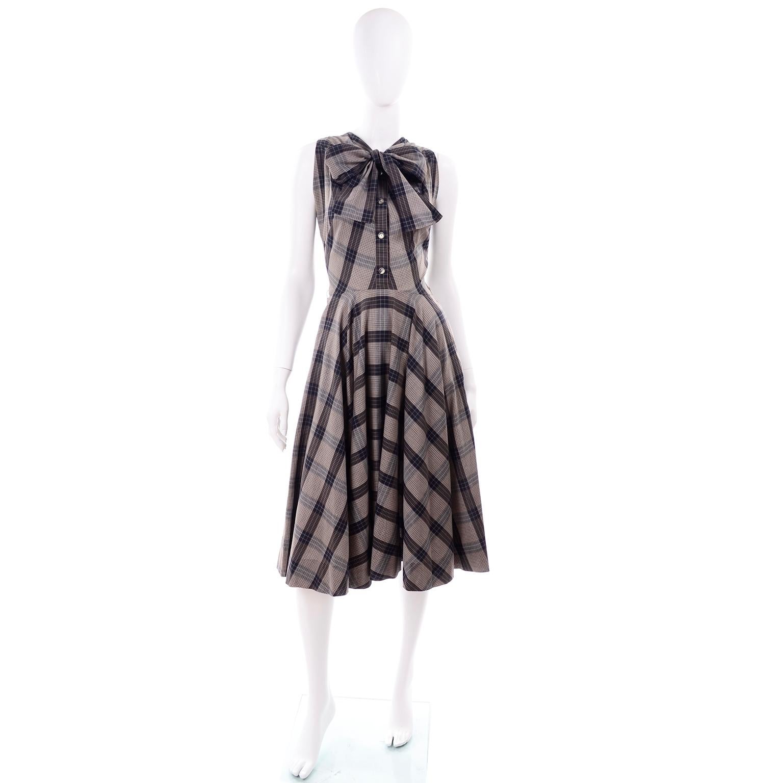 This 1950's vintage sand, gray and black plaid sleeveless dress is attributed to one of the mid century fashion designers accredited with inventing the genre of womens sportswear, Claire McCardell. What we especially love about it, regardless of who
