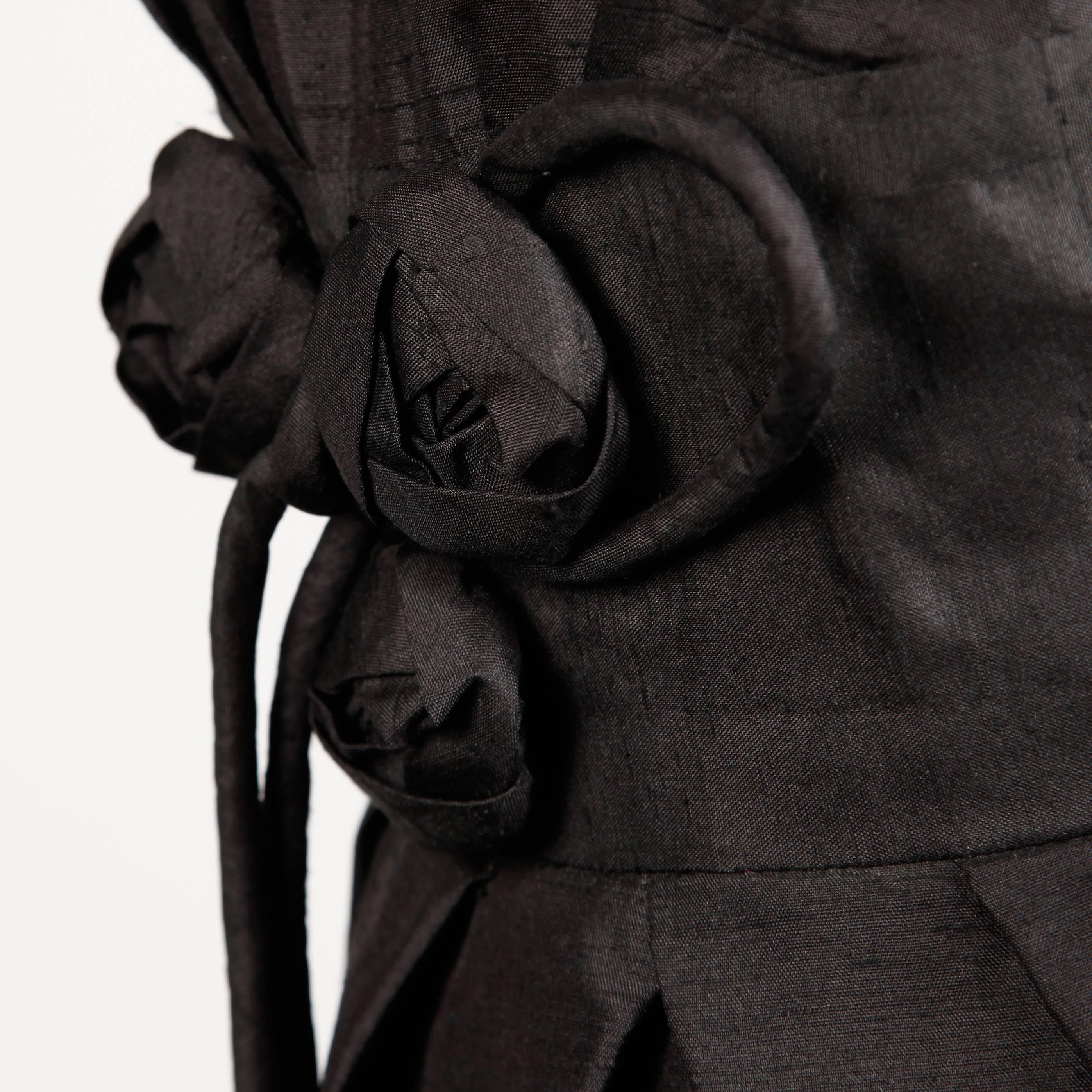 Abito da cocktail vintage anni '50 in seta grezza nera con dettaglio di fiori origami in vita. Classica Silhouette a clessidra anni '50!

Dettagli: 

Parzialmente foderato
Zip posteriore in metallo con gancio
Dimensioni stimate: Piccolo
Colore:
