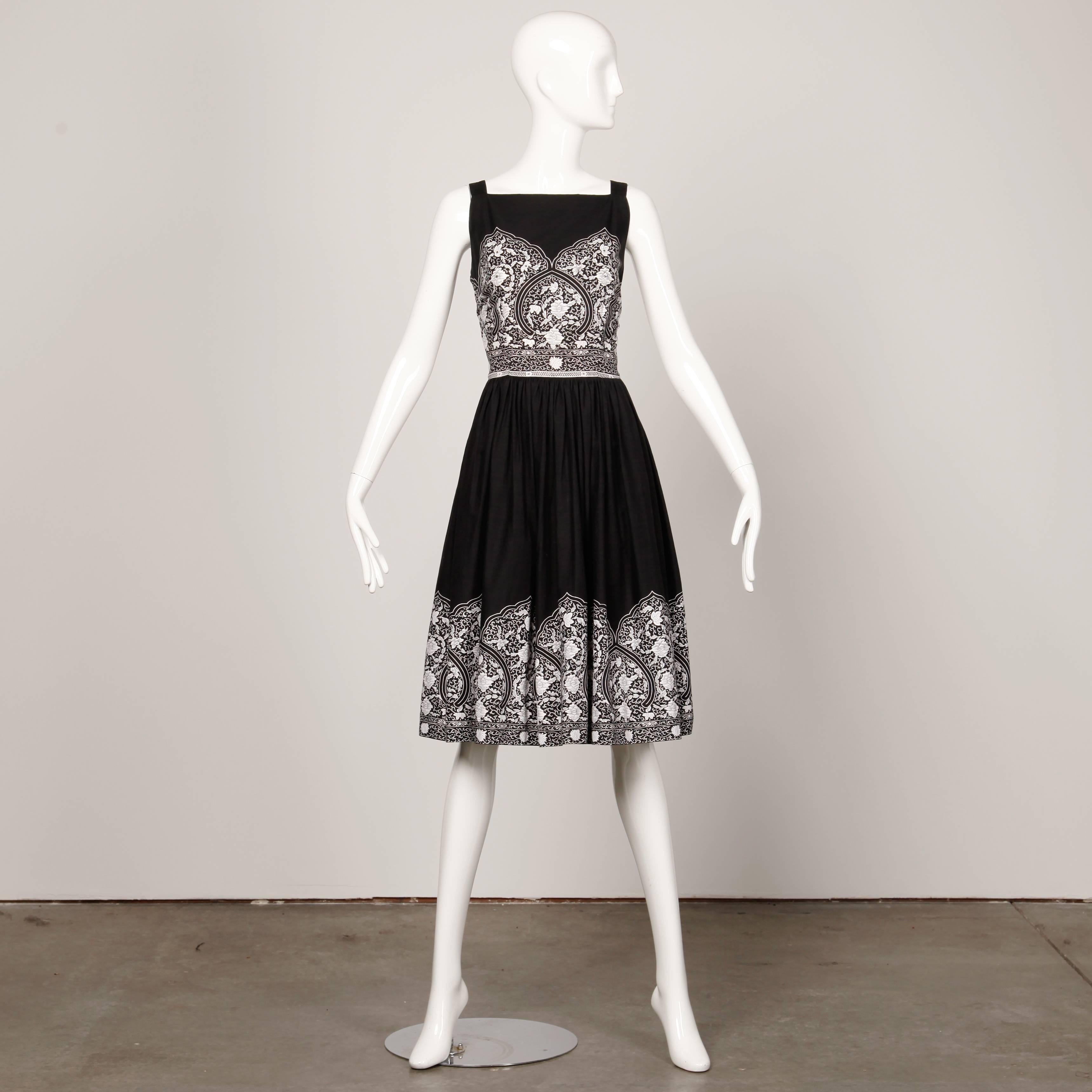 Ravissante robe de patio vintage des années 1950 en coton noir et blanc. Détails en strass sertis et jupe complète. Non doublée, avec une fermeture éclair métallique sur le côté. Correspond à une taille moyenne moderne. Le buste mesure 38