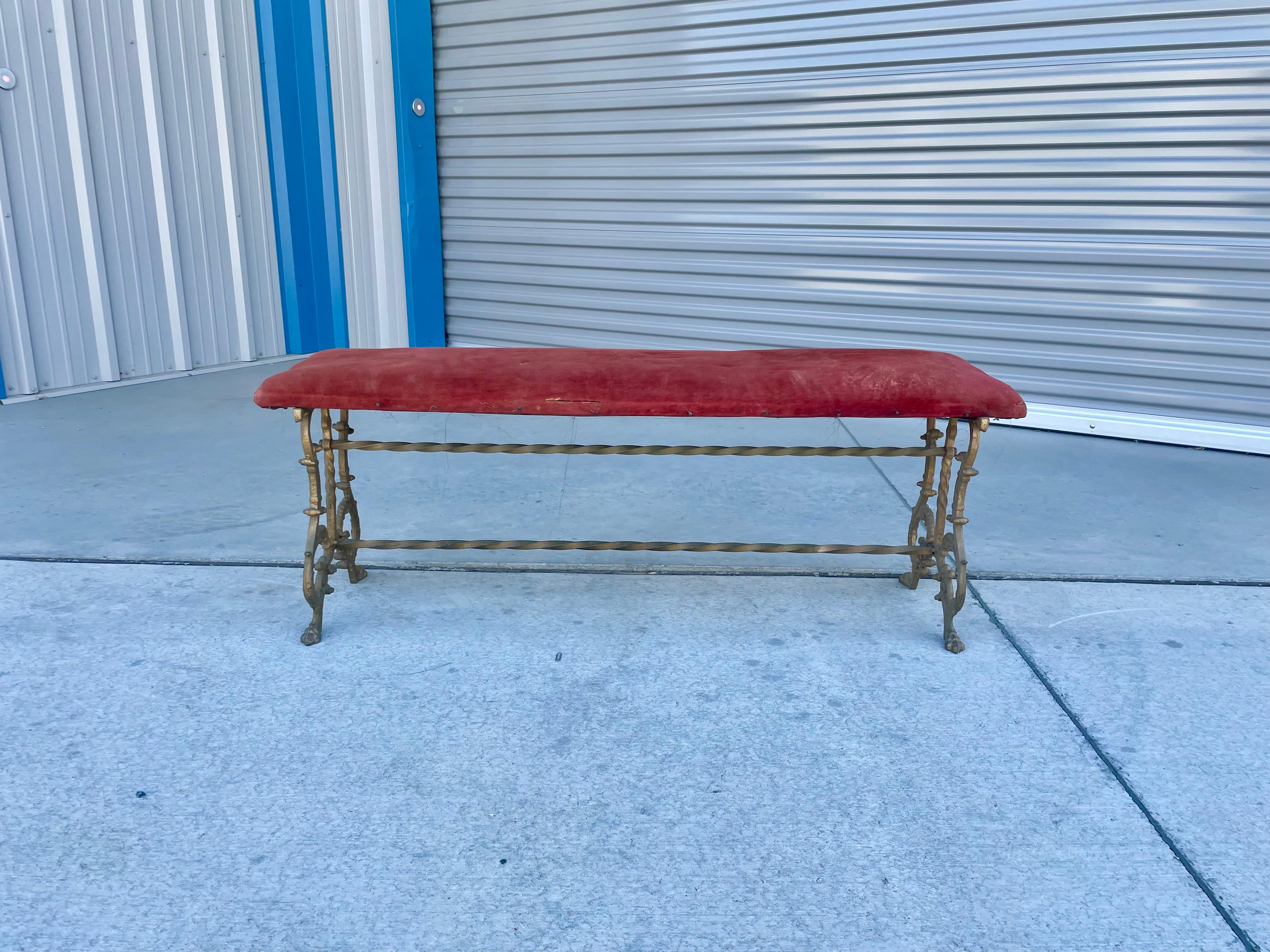 Vintage brass & velvet bench designed and manufactured in the United States circa 1950s. This stunning bench features a red velvet upholstery that sits on a brass base that adds a touch of sophistication and elegance.