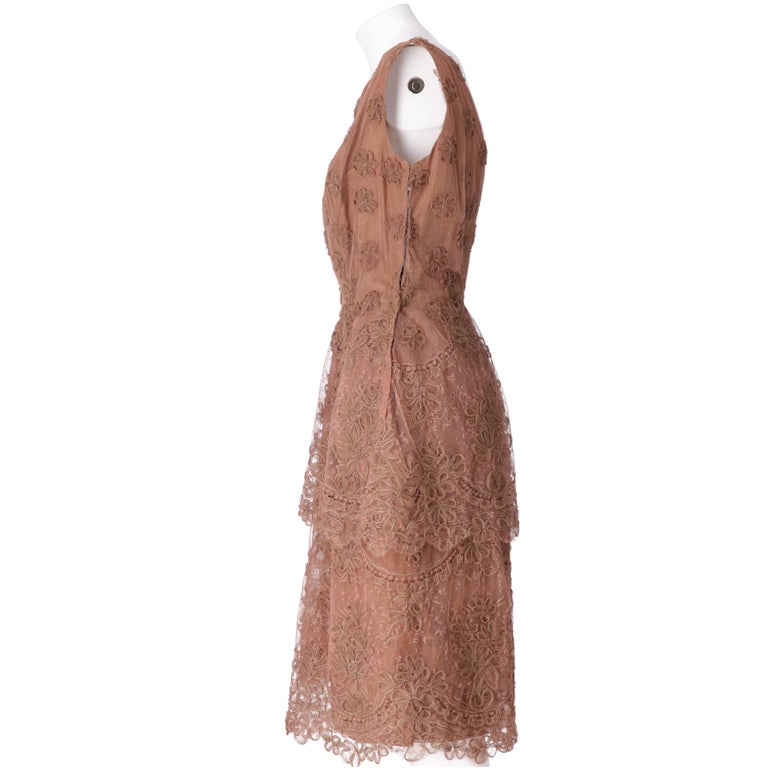 Complete in brown textured tulle composed of a dress and stole, flared and sleeveless dress with V-neck on the back, cut at the waist, just below the knee, double-layered with a shorter top layer, embroidered with tulle flowers, side closure with