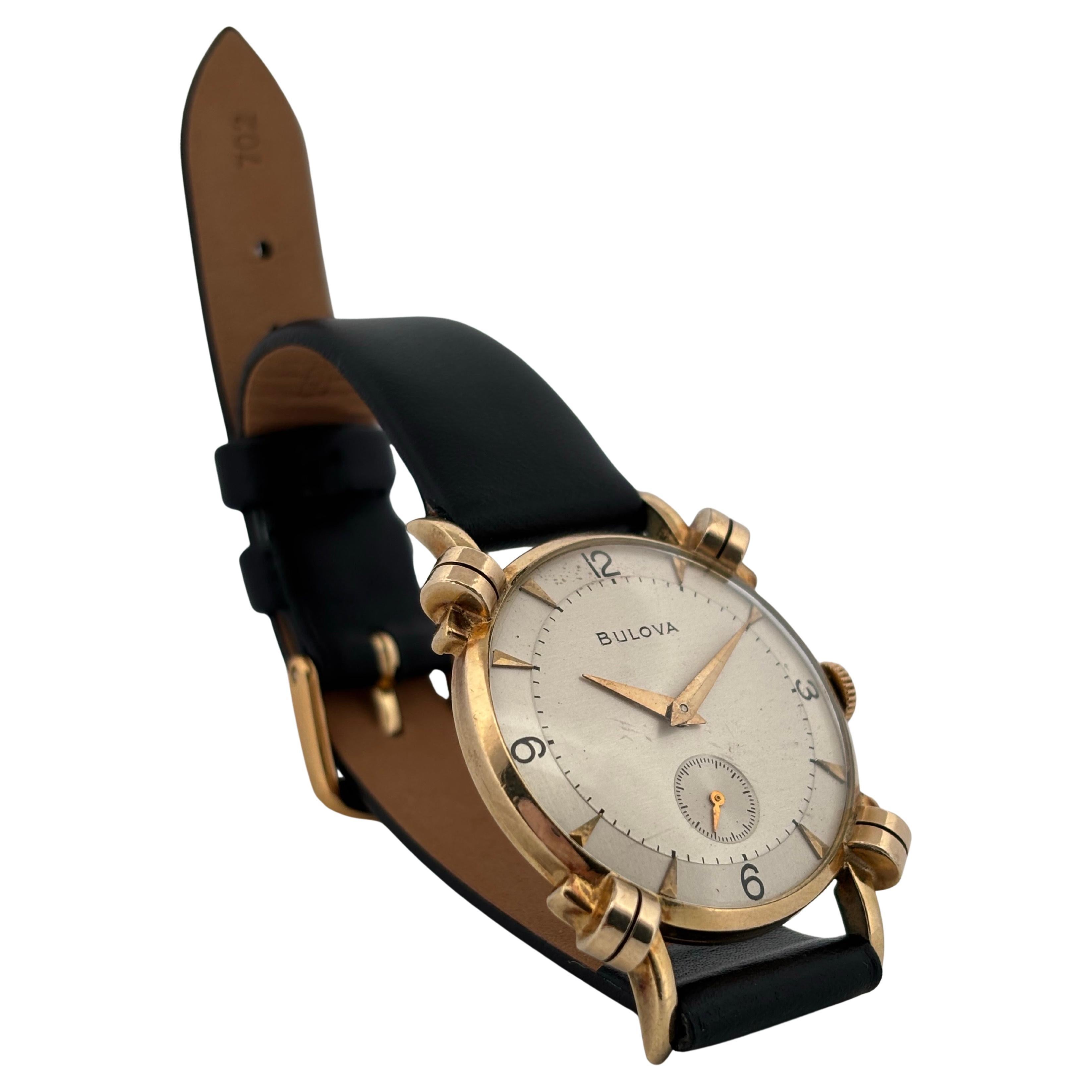 This vintage Bulova wristwatch from the 1950s exemplifies timeless elegance and refined craftsmanship. Housed in a 10k rolled gold plate case measuring 29mm, the watch features a distinctive design highlighted by rare scrolling lugs that set it