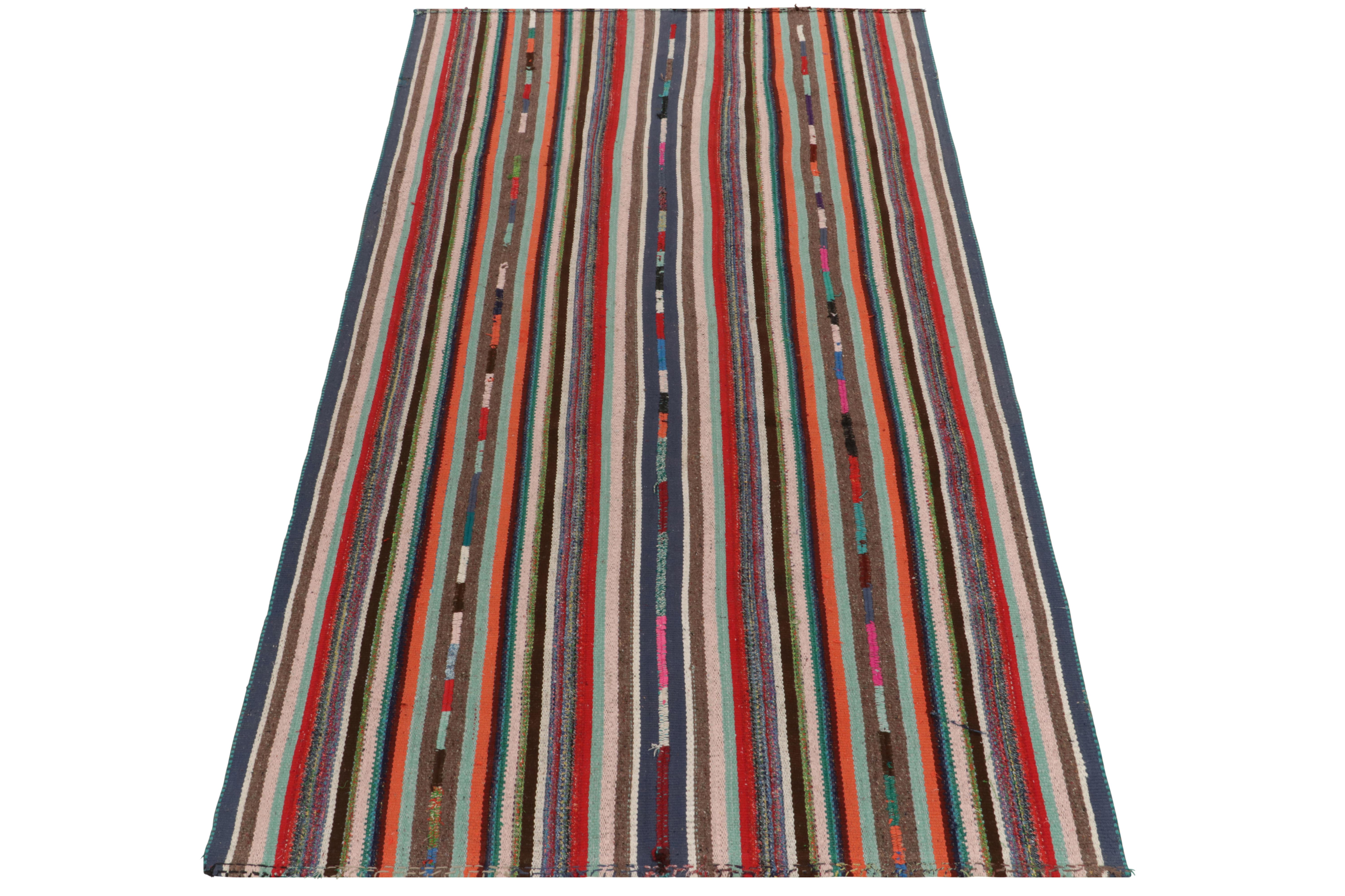 Diese seltene Art von Kelim-Teppich stammt aus der Türkei (ca. 1950-1960) und wird jetzt in unser Antiquitäten- und Vintage-Sortiment aufgenommen. Das lebendige Stück, das sich durch feine Details in den Farben der polychromen Streifen auszeichnet,