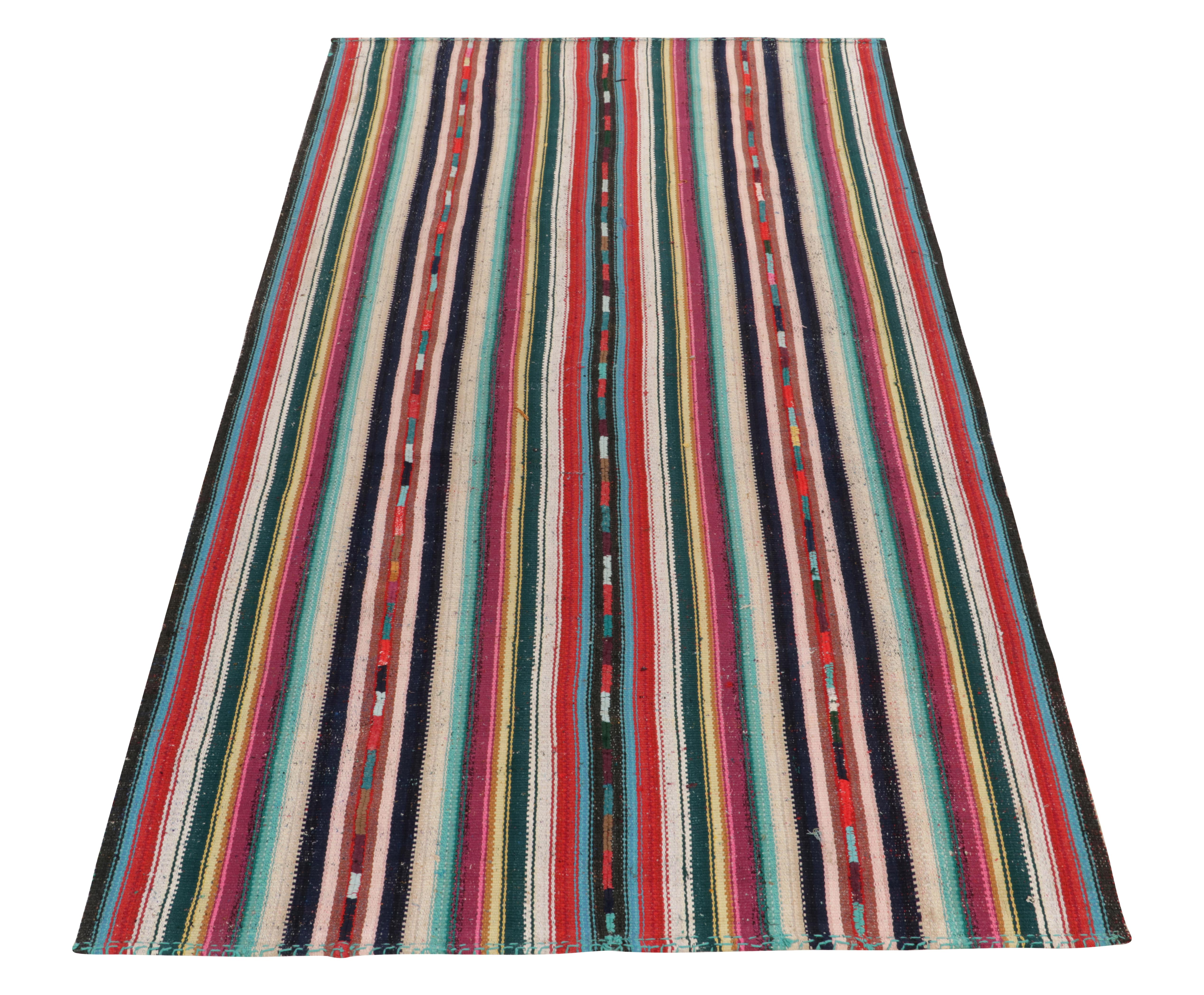 Hailing from Turkey circa 1950-1960, a rare type of vintage chaput kilim rug style from a special new curation. Characterized by fine detailing with the colors within the polychromatic stripes, this piece with fabulous hues invites a departure from