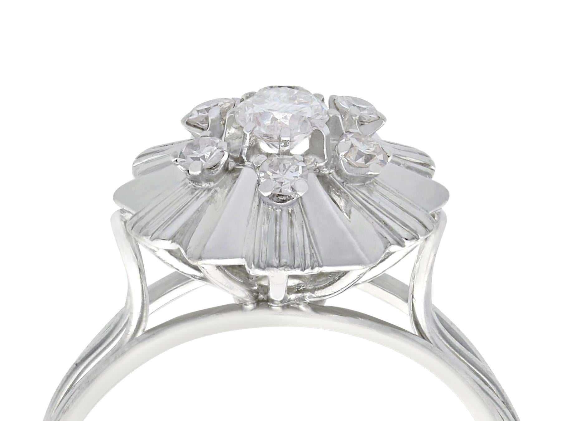 A fine and impressive vintage 0.62 carat diamond and 18 karat white gold cocktail ring; part of our vintage jewelry/estate jewelry collections

This impressive vintage diamond cluster ring has been crafted in 18k white gold.

The impressive pierced