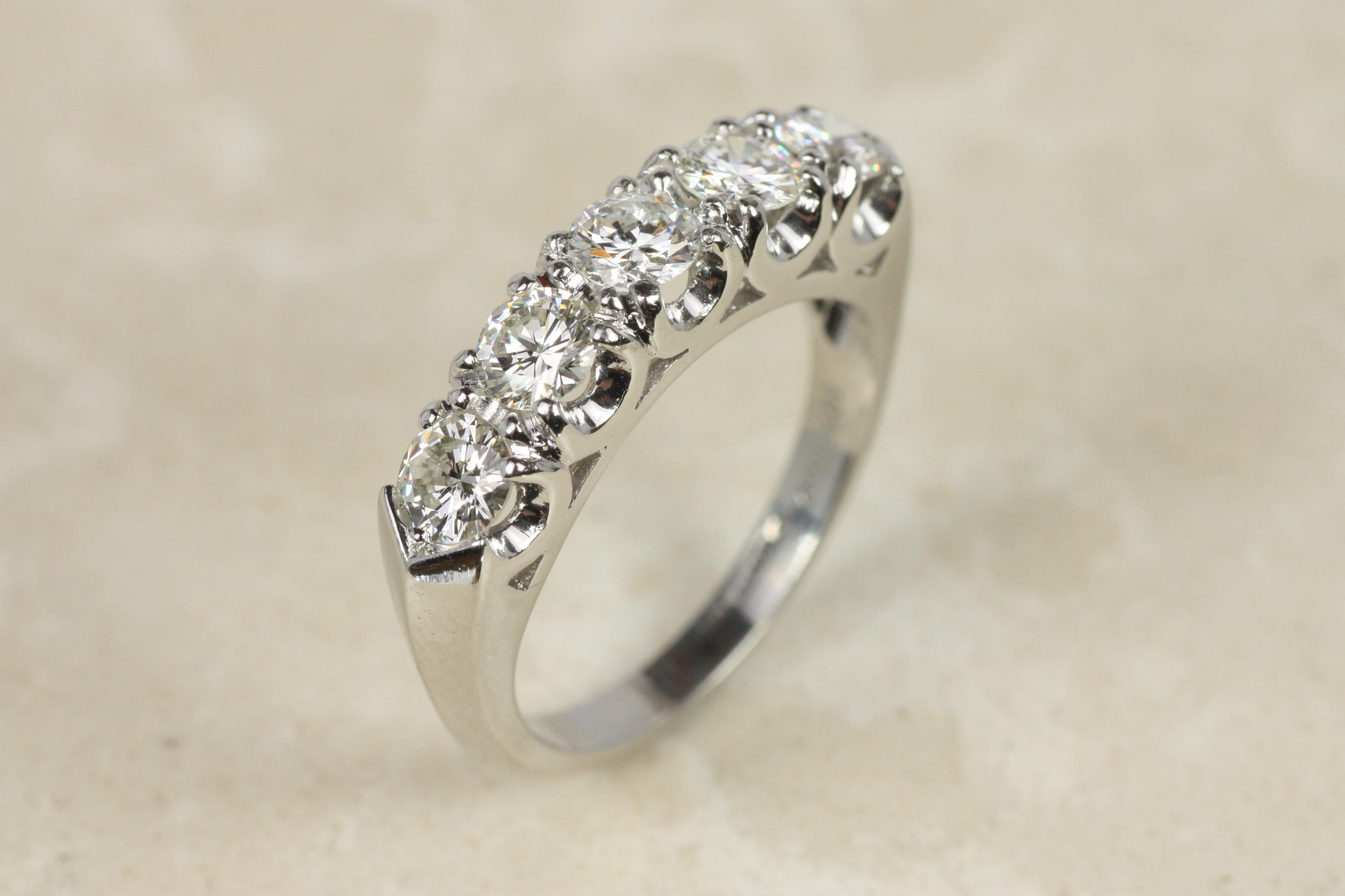 This genuine 1950s vintage diamond wedding band is a beautiful piece from our fine estate jewelry collection in Santa Monica, California. Featuring 5 round natural diamonds totaling 1.00cttw (VS1-SI2, H) set in a platinum fishtail prong setting with