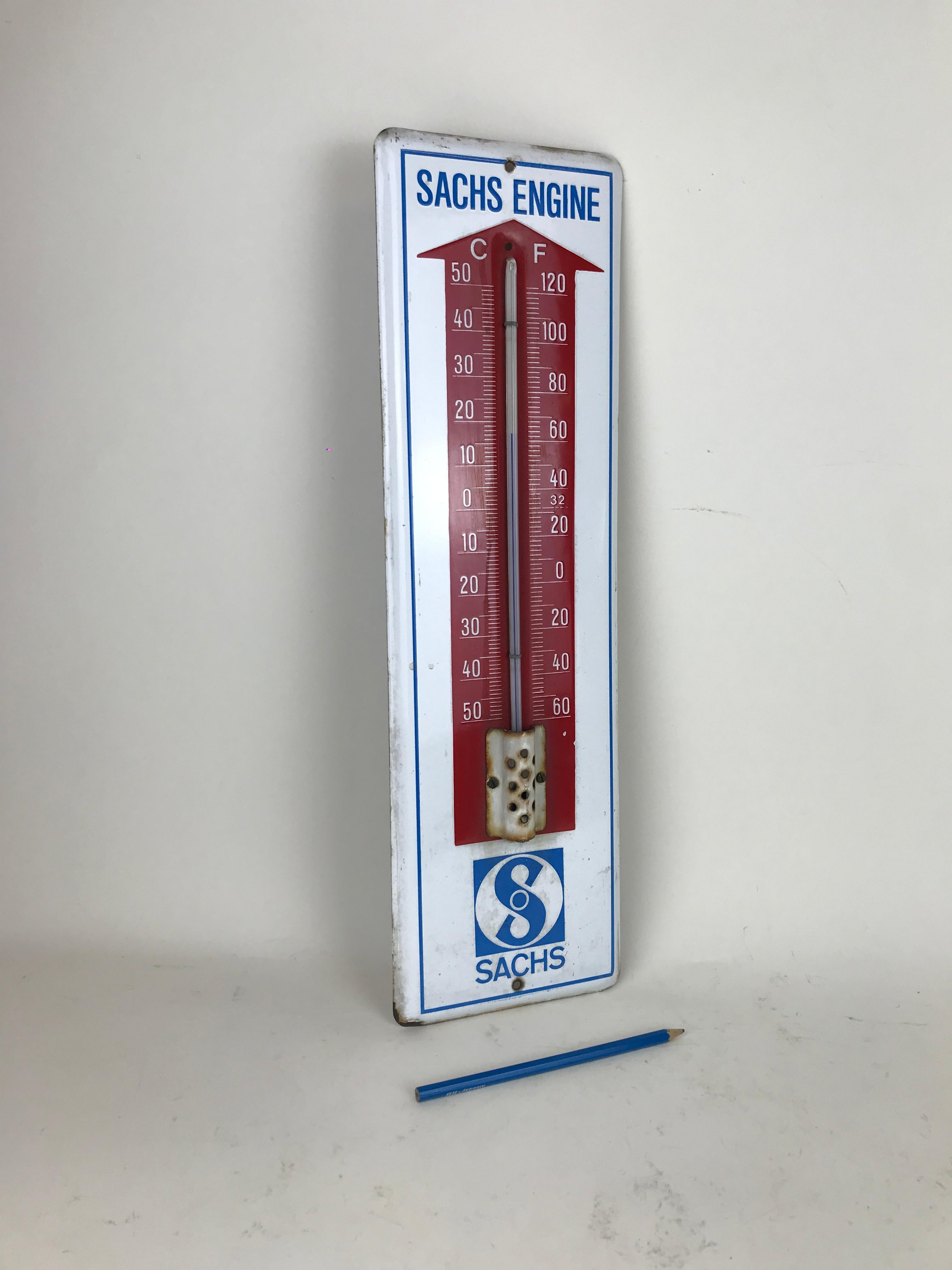 Vintage advertising enamel metal wall thermometer by Sachs Engine made in Germany in the 1950s, in white, red and blue color.

The thermometer is working showing temperature both in Celsius degrees and Fahrenheit.


Collector's note:

ZF