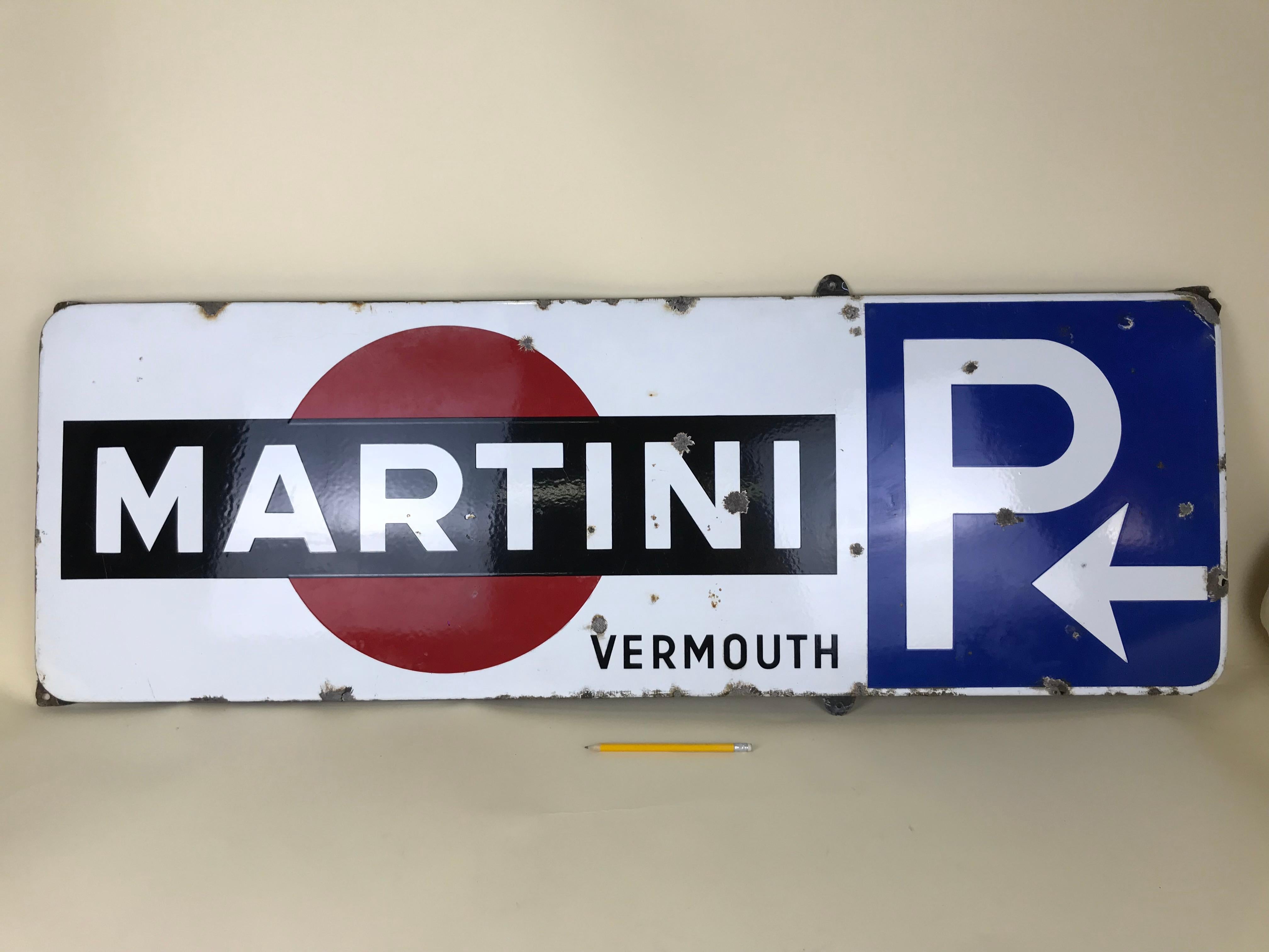 This rare enamel metal sign of Martini was produced in the 1950s in Belgium for advertising purposes.
In this sign the Martini logo is placed on white background and accompanied by word 