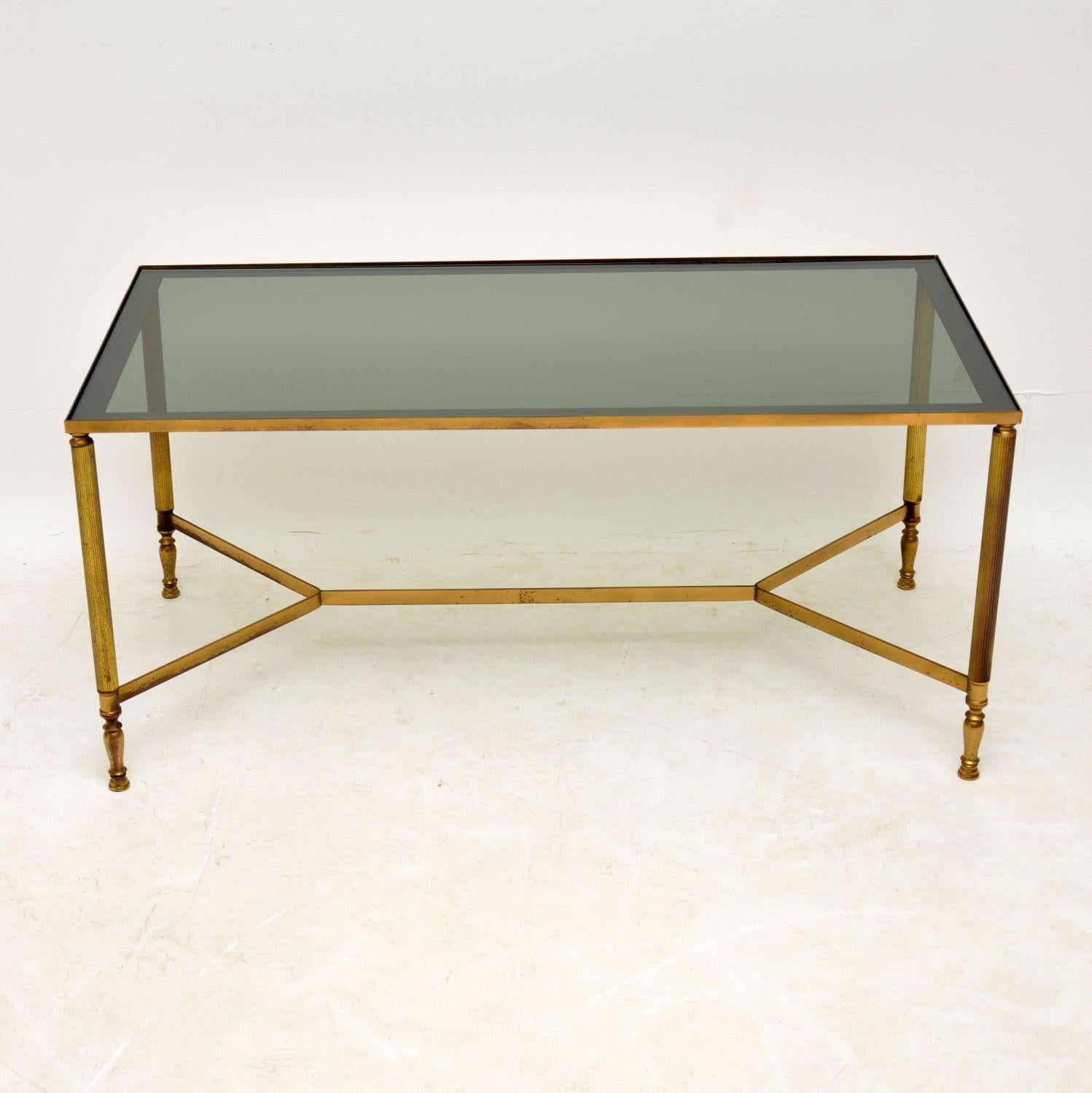 A smart and elegant vintage French coffee table in brass and glass, this dates from the 1950s-1960s. It has just the right amount of wear, with a beautiful patina, this table is sturdy and sound. The glass has some minor surface wear, as expected