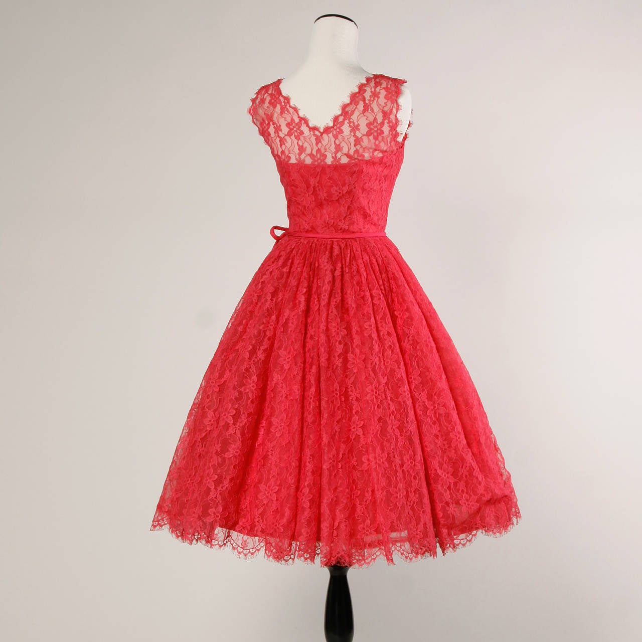 Vibrant fuchsia pink cocktail dress from the 1950s. Full sweep and scalloped edges.

Details:

Partially Lined
Side Metal Zip and Hook Closure
Marked Size: Not Marked
Estimated Size: XXS
Color: Bright Fuchsia Pink
Fabric: Lace/ Tulle/ Nylon
Label:
