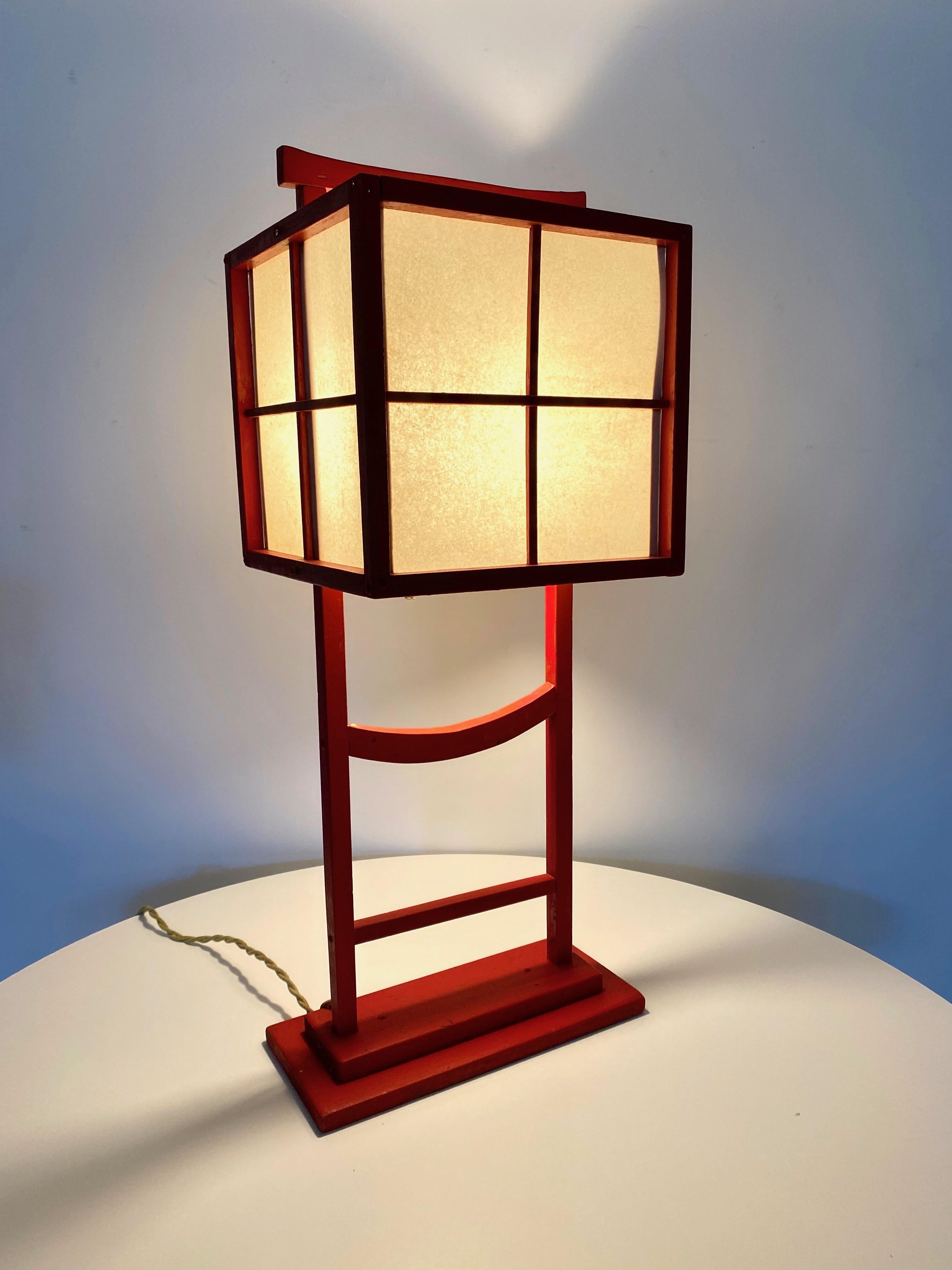 Andon table lamp hand crafted sometime in the early 1950s signed on the bottom Tomiko. Made entirely by hand with red painted wood frame and fiberglass parchment panels. Has a warm naive quality to this traditional style of Japanese lighting.