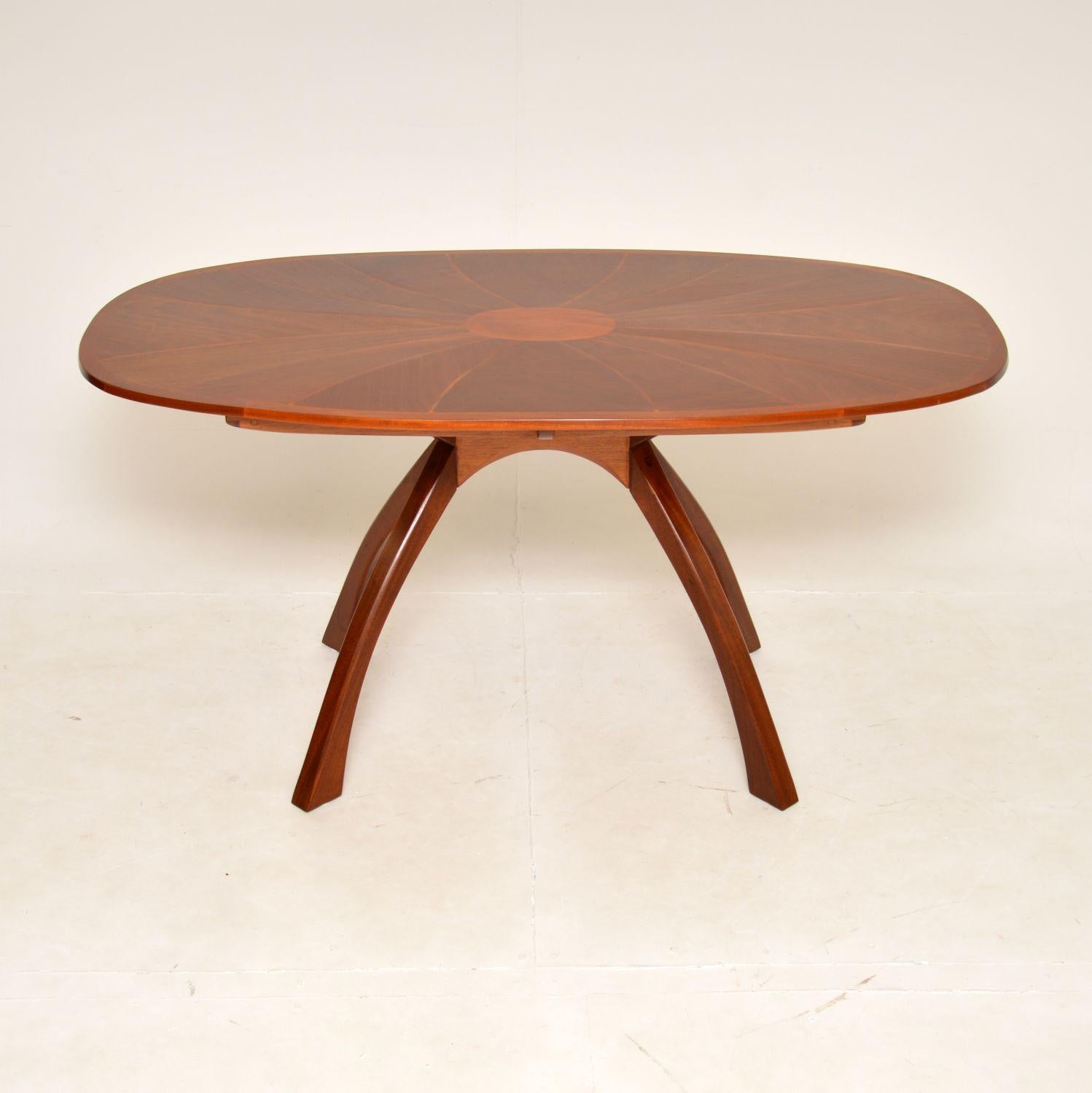 A stunning and very unusual vintage oval dining table. This was made in England, quite possibly by Heal’s, it dates from around the 1950’s.

It has a spectacular design, with beautifully inlaid walnut top sitting on a bowed spider shaped base. The
