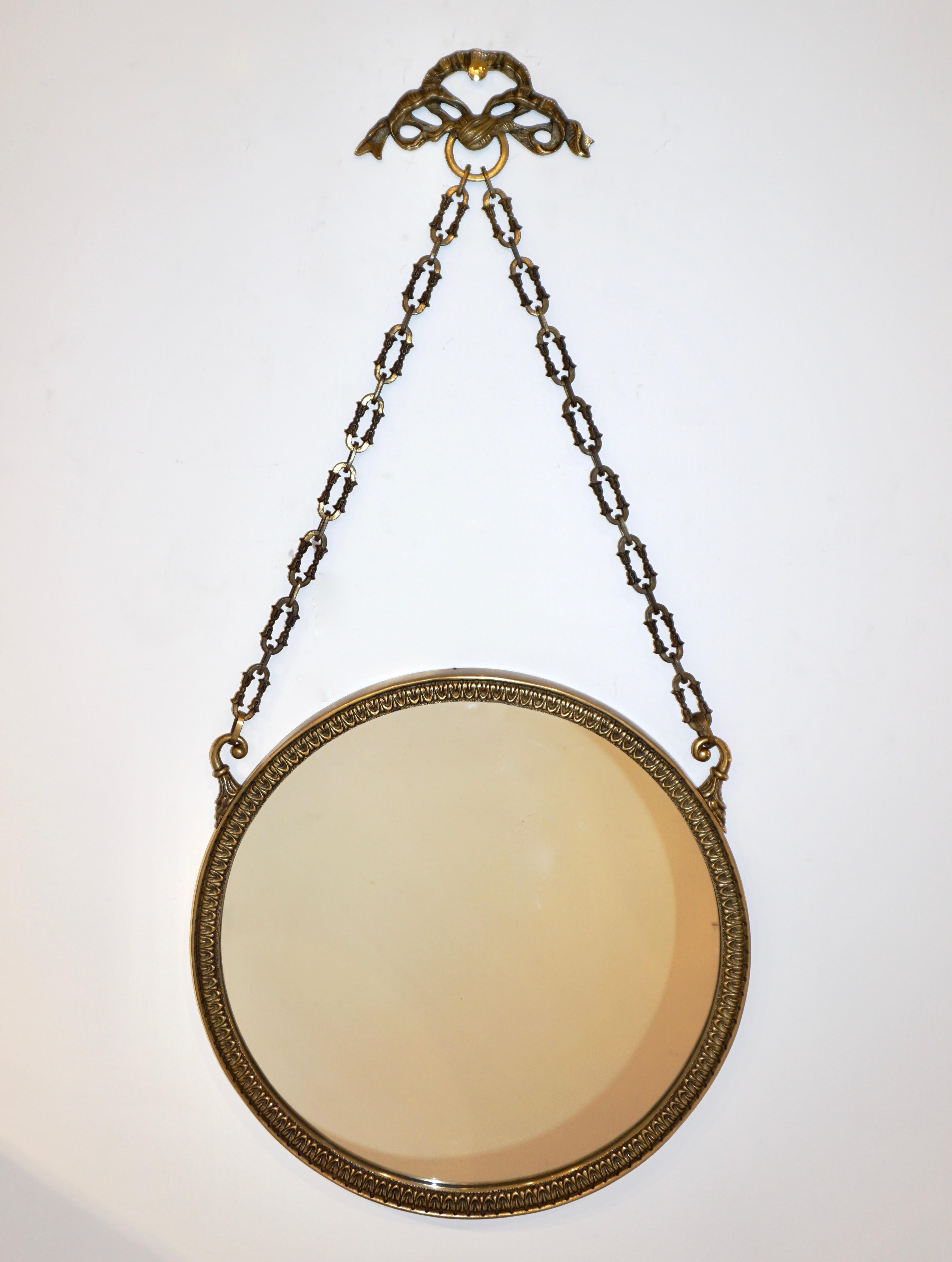 Louis XVI style charming wall mirror, entirely handcrafted in bronze. The round plate is encased in a chased frame with heart leaf decor in relief, hanging from 2 chased hooks with a decorative chain and knot. High quality of execution, ideal for a