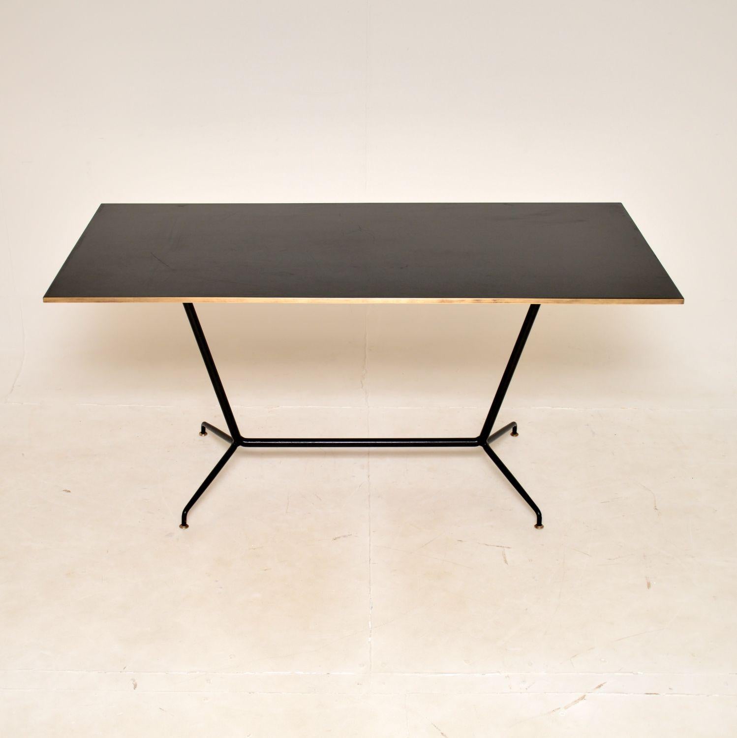 A stunning vintage Italian desk, beautifully executed in steel, brass and Formica. This dates from around the 1950-60'.

It would be equally useful as a desk or small dining table, and has an incredibly stylish design. The ebonised steel base has