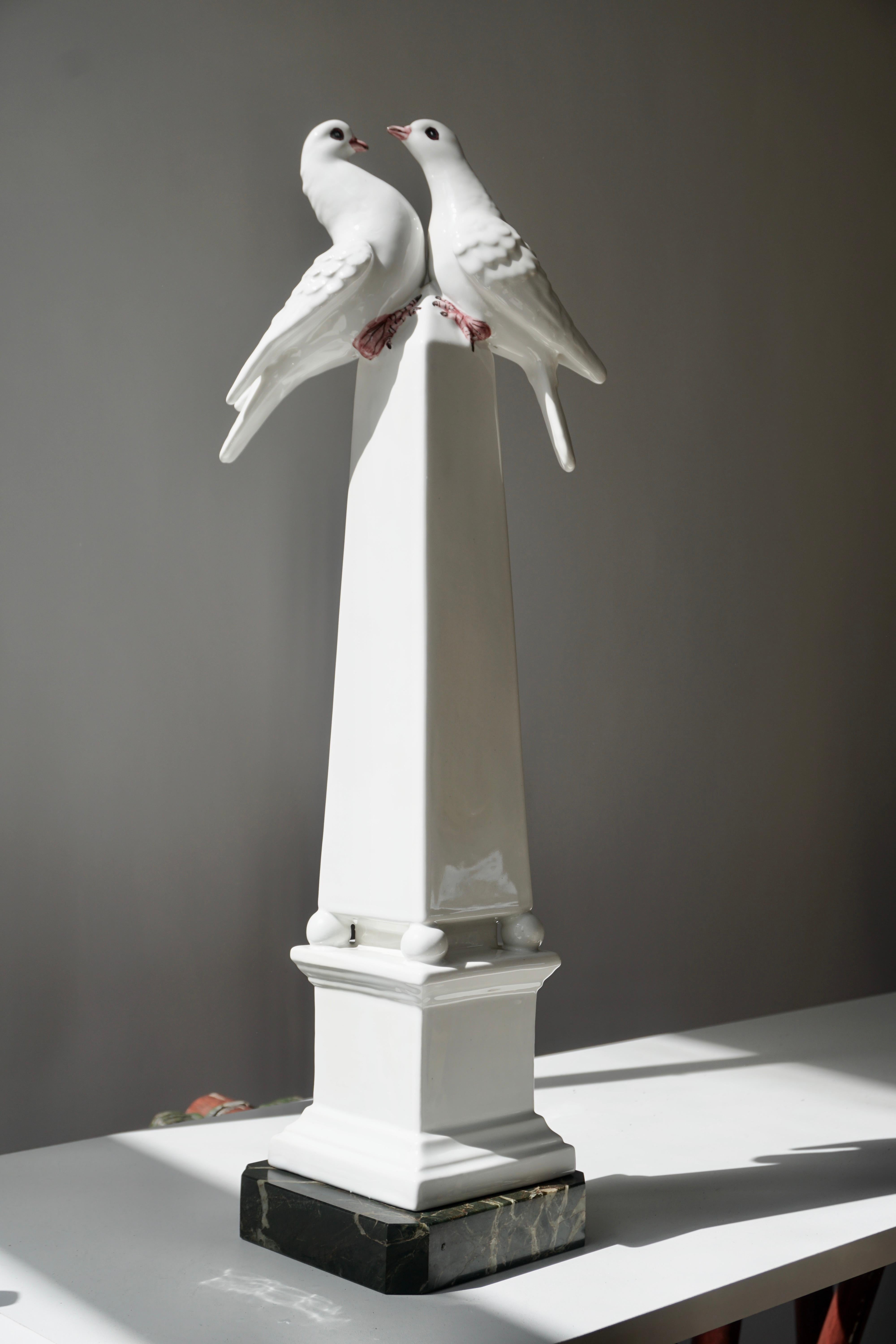 A gorgeous porcelain obelisk on a marble base. The lovely white color porcelain obelisk with highly crated white, hand painted love birds on the top. 
Great condition. Italy 1950s.
Measures: Height 55 cm , width 15 cm, depth 15 cm.
Weight 2