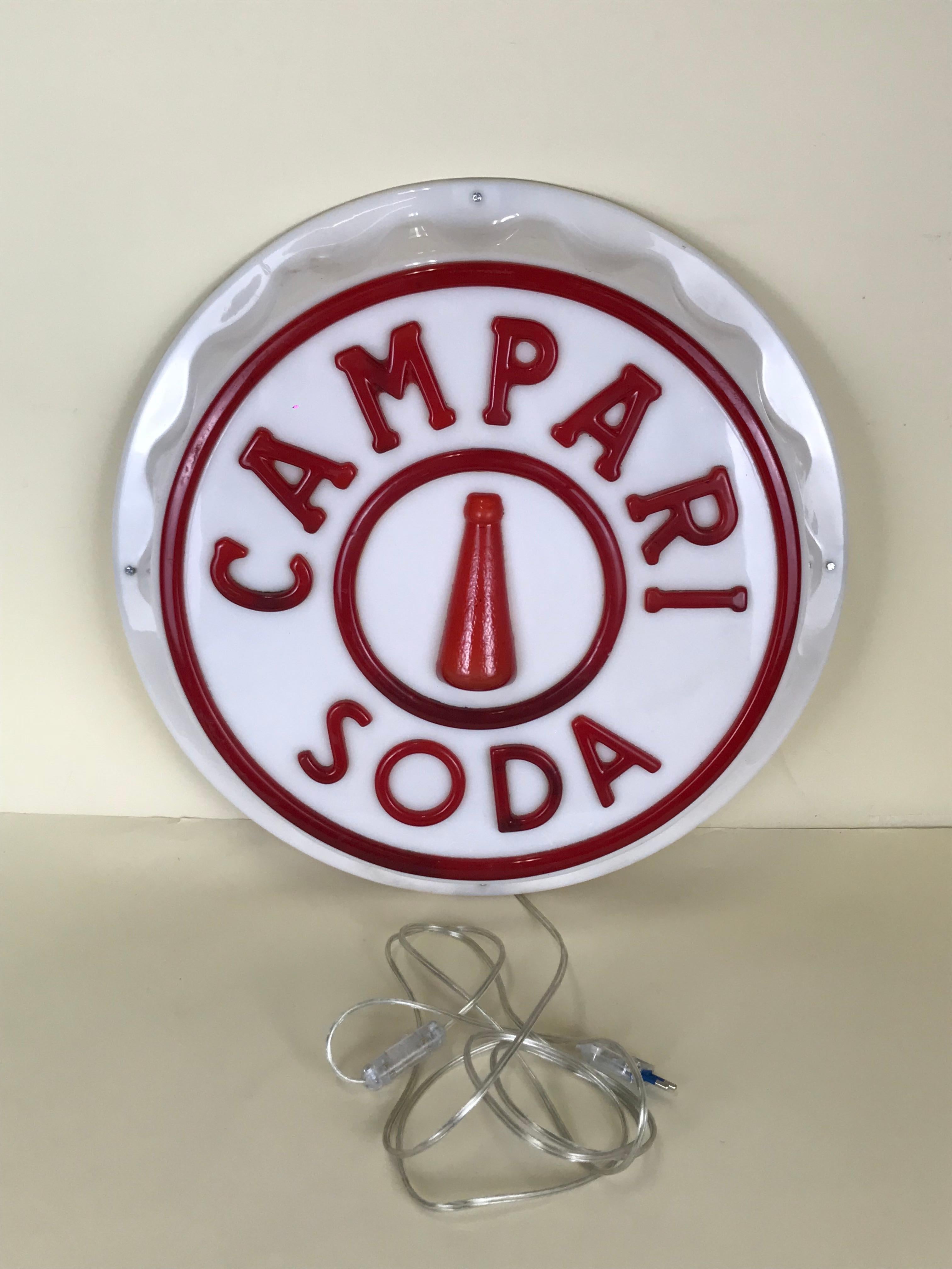 Campari soda illuminated plug shaped sign with relief letters produced in Italy in the 1950s. This very rare illuminated sign it was displayed in a selected numbers of Italian bar.

The back of the sign is not original: is now covered in wood