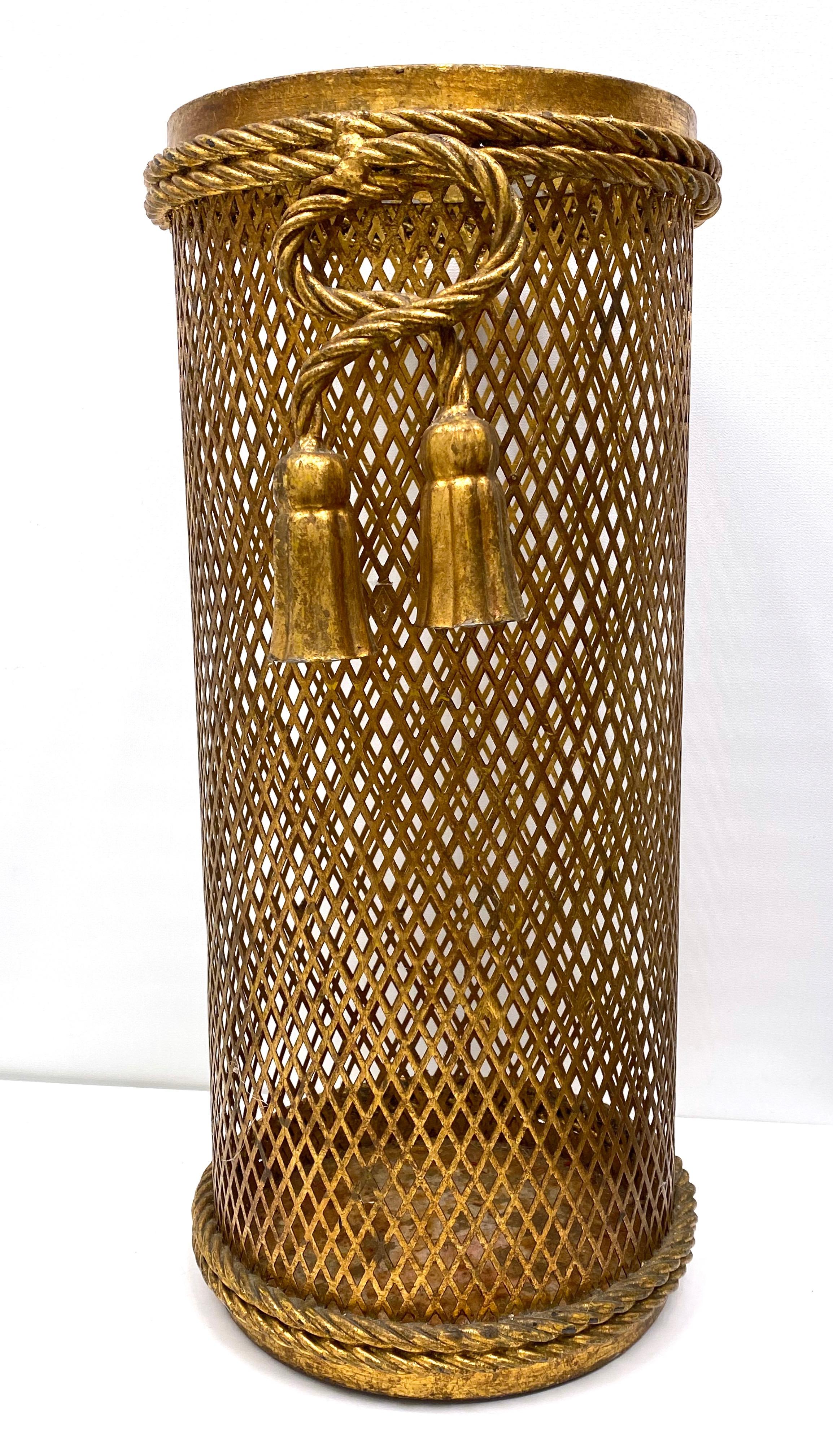 A gorgeous Hollywood Regency umbrella stand. Made of gilded metal. Some minor dents and paint lost appear but this is old-age. Made in Florence, Italy, circa 1950 by Li Puma Firenze. The perforated lattice patterned metalwork with bent rope and