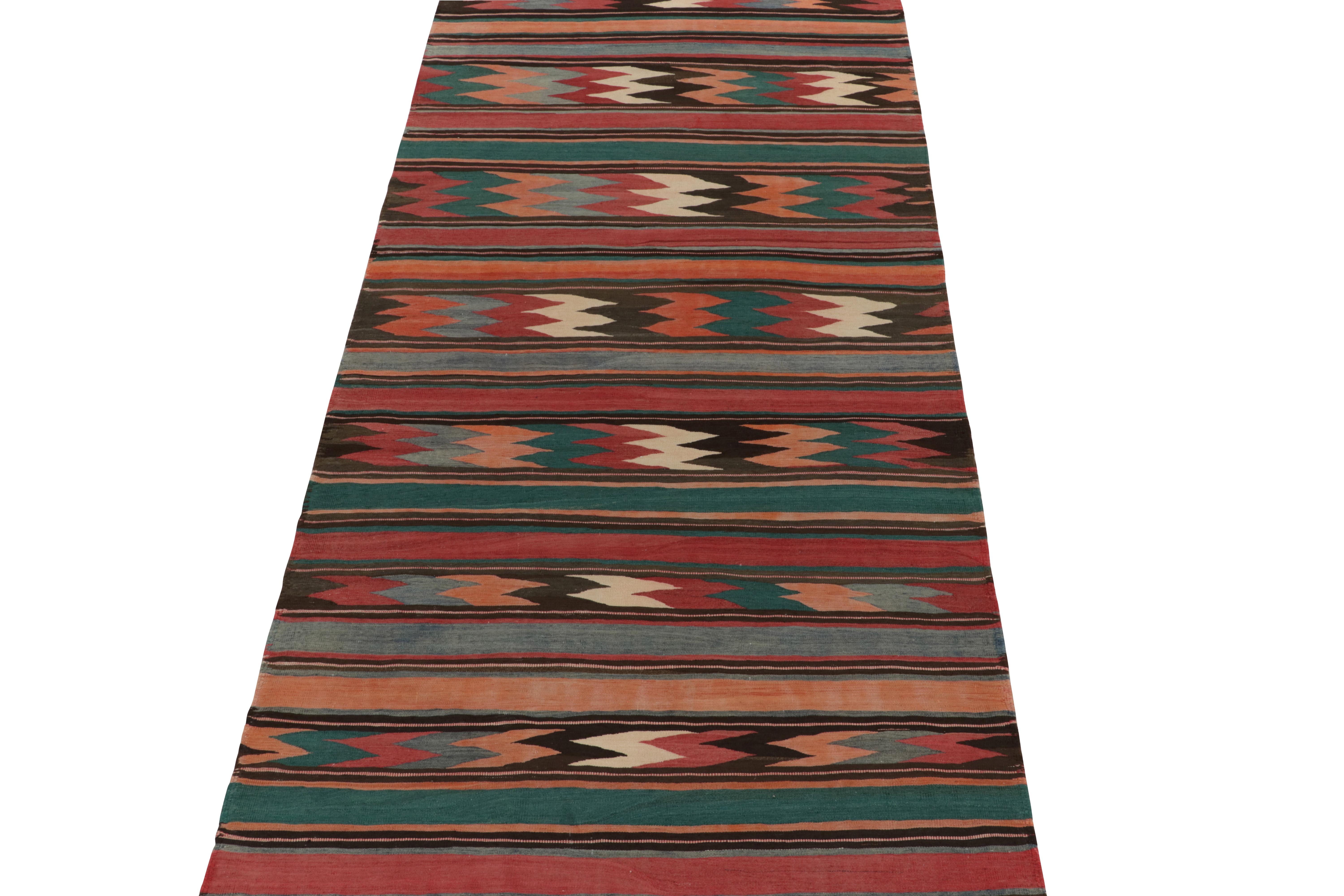 Coming from Turkey circa 1950s, a 5x11 mid-century tribal Kilim now entering R&K’s vintage flat weave selections. 

Distinguished for both its size and vibrant colorways among flat weaves of the 1950s, the piece carries a unique attitude and a