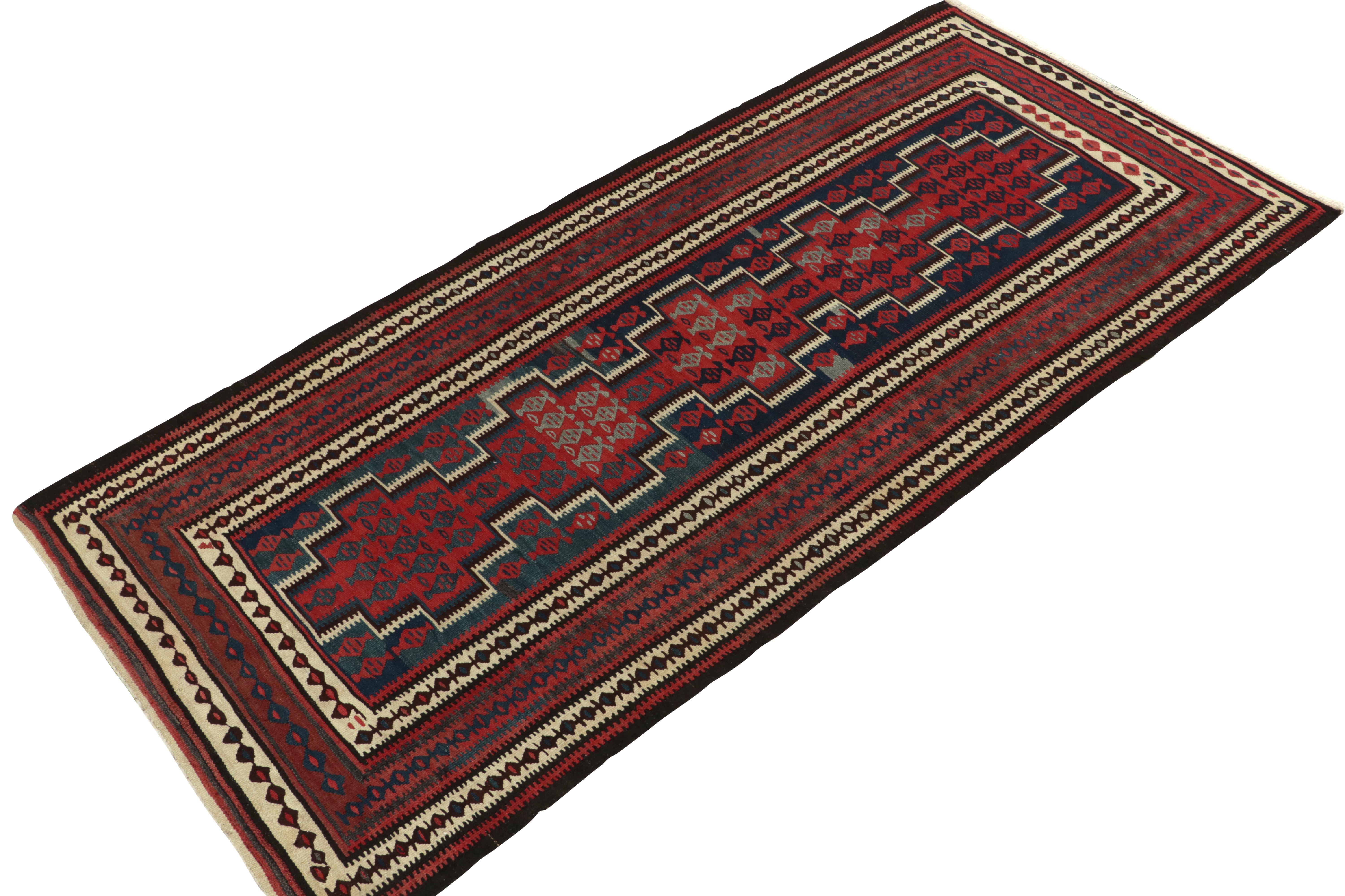Originating from Turkey circa 1950-1960, a mid-century kilim rug enjoying a meticulous all over pattern. Featuring a well defined traditional pattern in red, blue & beige-brown with outstanding finesse, a 4x9 piece thriving in good condition well