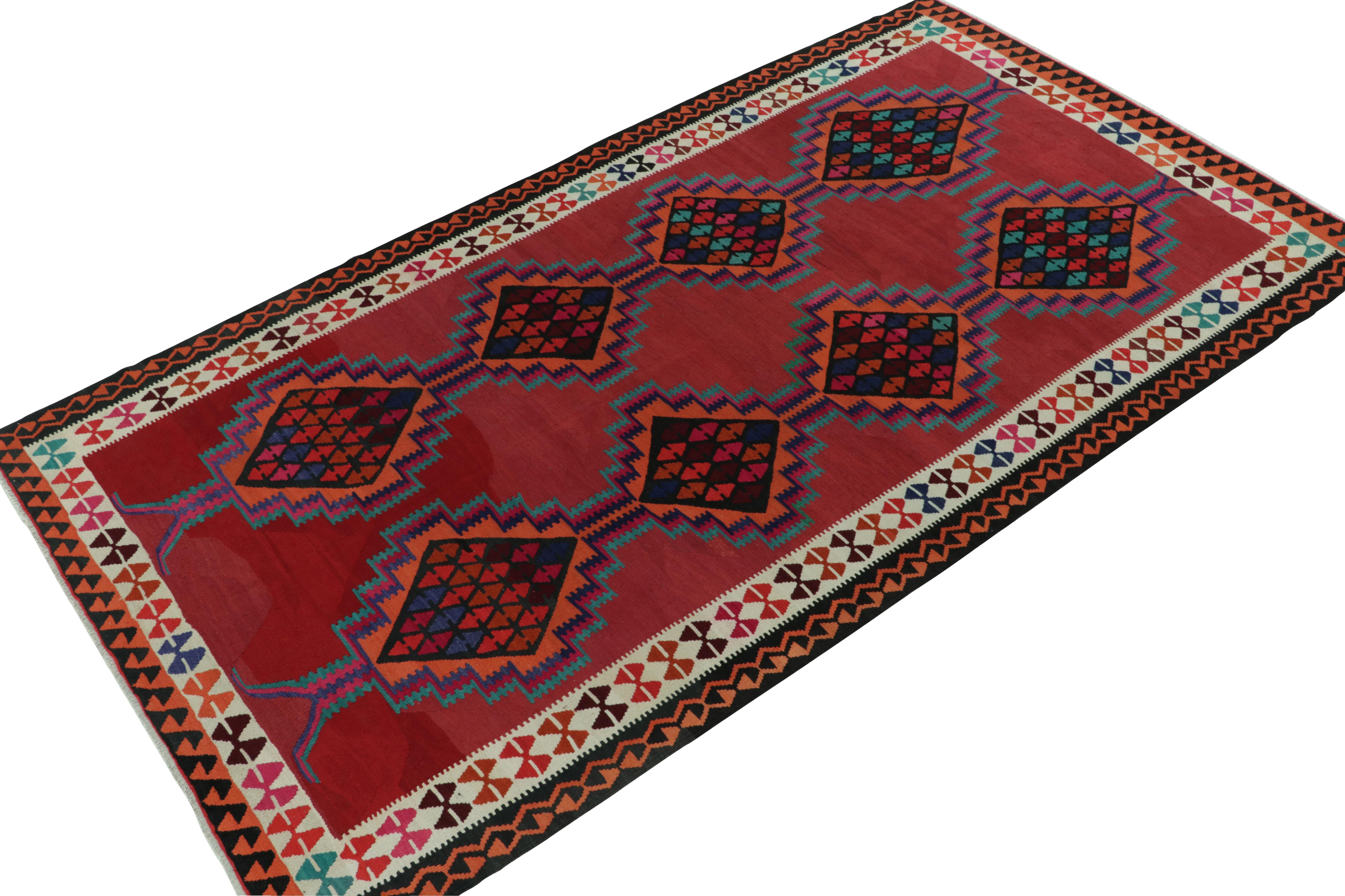 Originating from Turkey circa 1950-1960, a mid-century kilim rug. Featuring a well defined traditional pattern in vivid tones of red, orange, blue and brown with alluring and bold accents, a piece thriving in good condition for an array of projects.