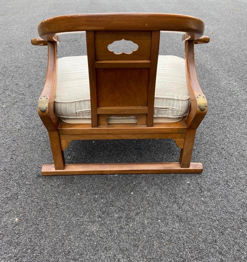 Oriental Lounge Armchairs designed by Michael Taylor from the Far East Side Collection for Baker Furniture with brass accents, low sleek form, and wonderful carvings. Baker label to the underside of both chairs.