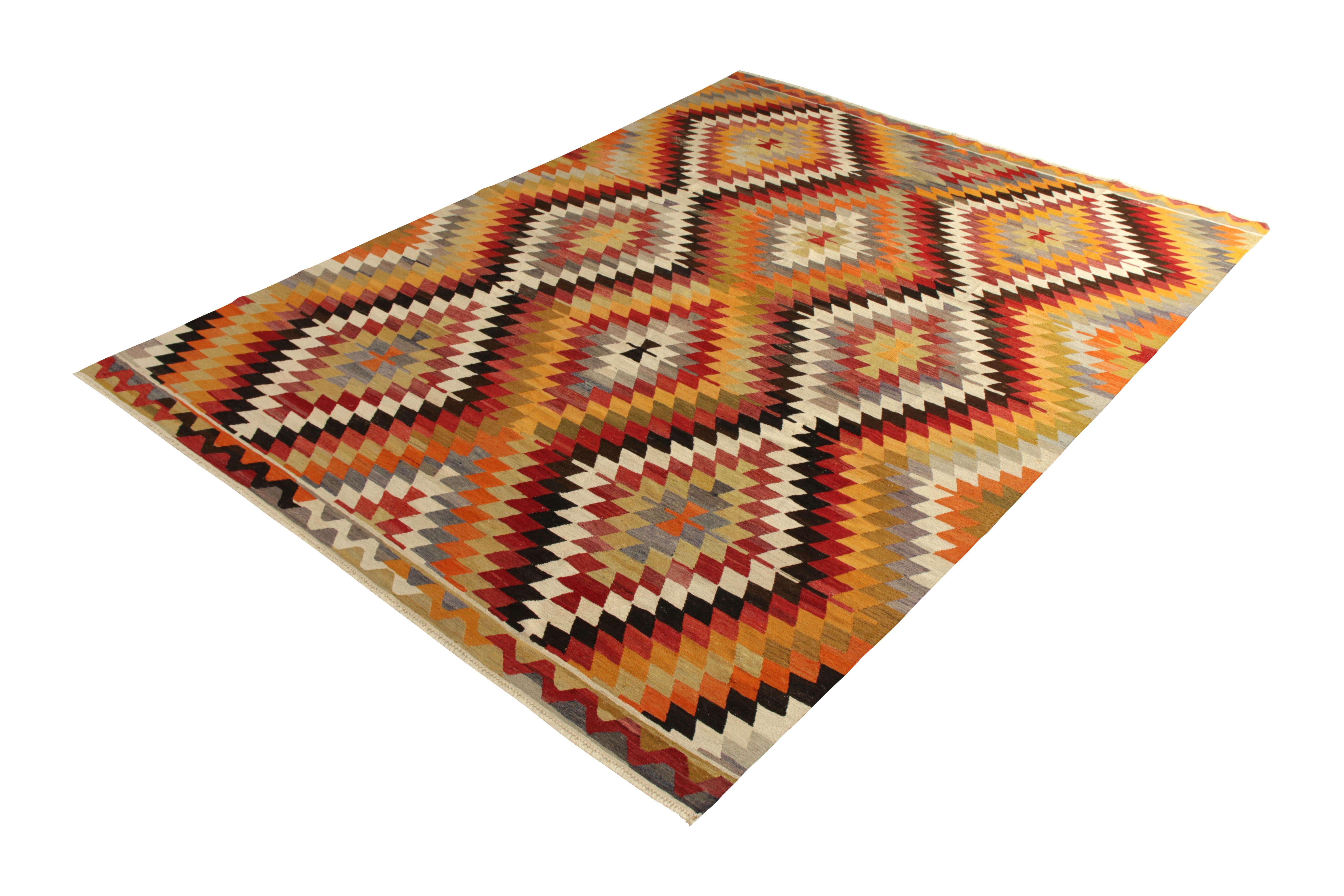 Handwoven in wool originating from Turkey circa 1950-1960, this item is a vintage Kilim rug connoting a midcentury Turkish diamond pattern emerging in this period, known for producing Kilim rugs with modern and maximalist appeal in the geometry and