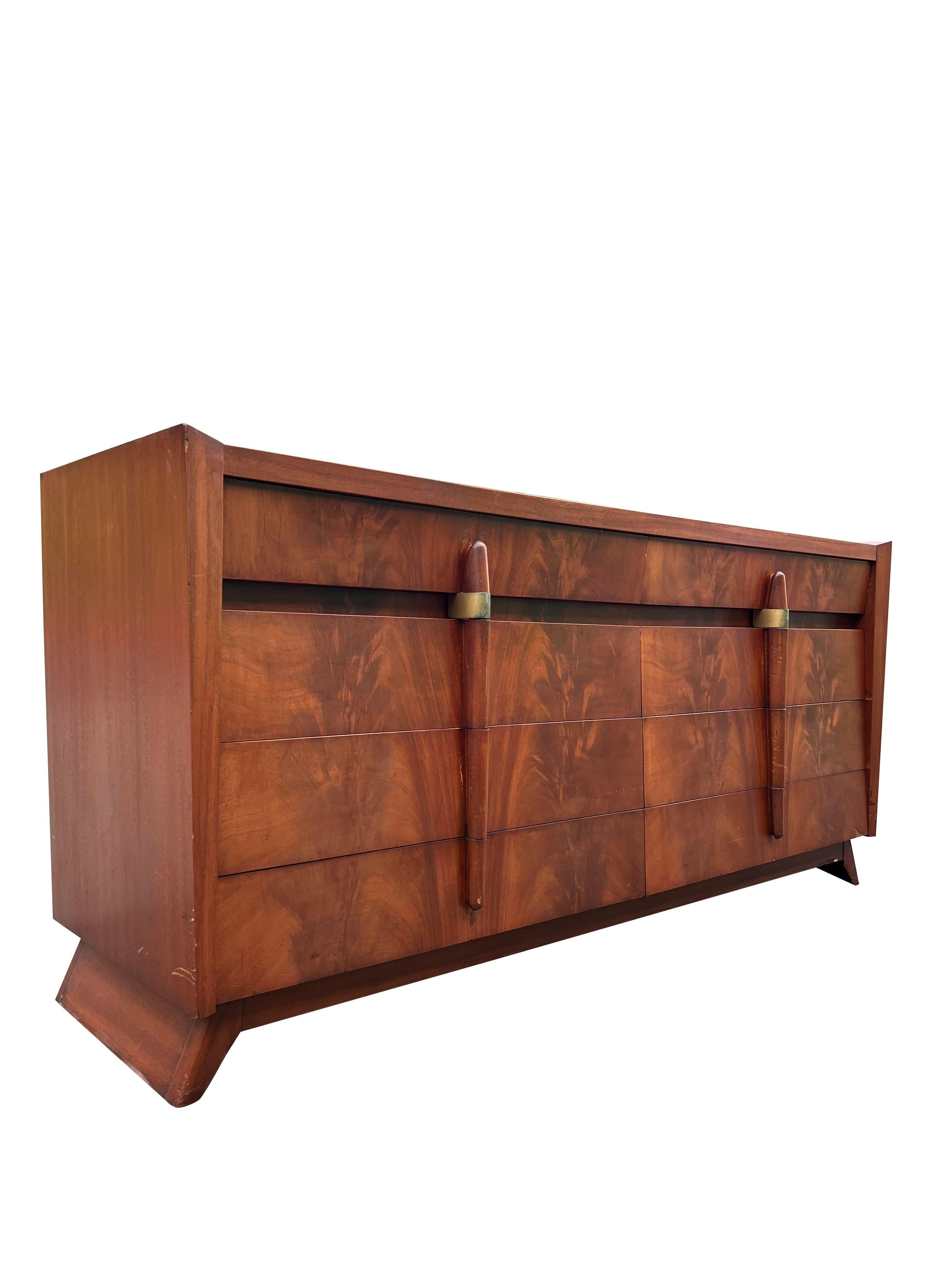 Vintage Mid-Century Modern Streamline Deco Long Dresser

Vintage: 1950s Mid-Century Modern Streamline Deco Long Dresser
Style: Streamline Deco
Material: Mahogany wood with brass details
Dimensions: 72ʺW × 21ʺD × 33.5ʺH
Condition: Good Condition,