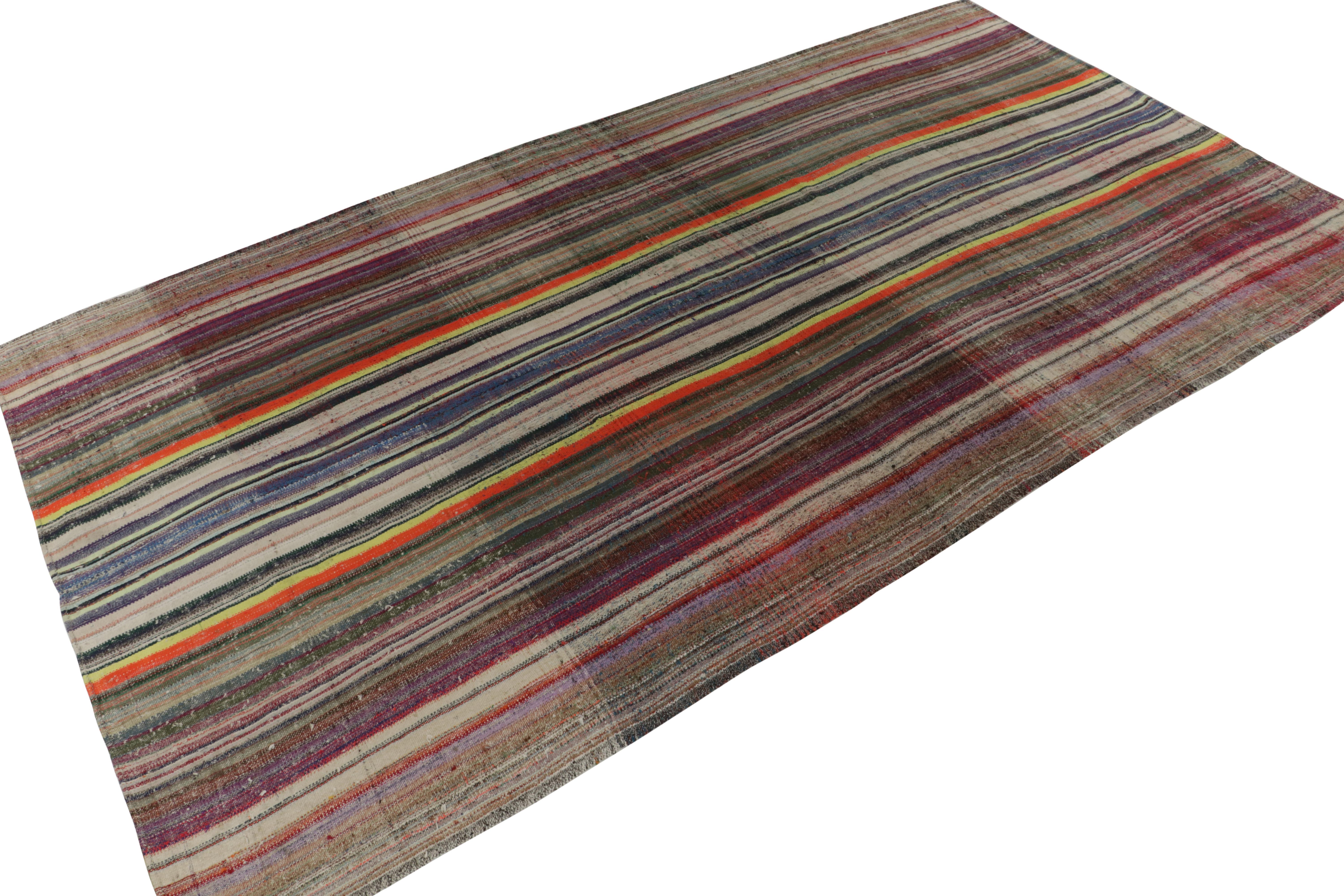 Handwoven in wool, a vintage Turkish kilim rug, connoting a rare variant of mid-century panel weaving styles circa 1950-1960. The sheer rarity of this large 10x15 size and the colorful polychromatic stripes is both extremely collectible and