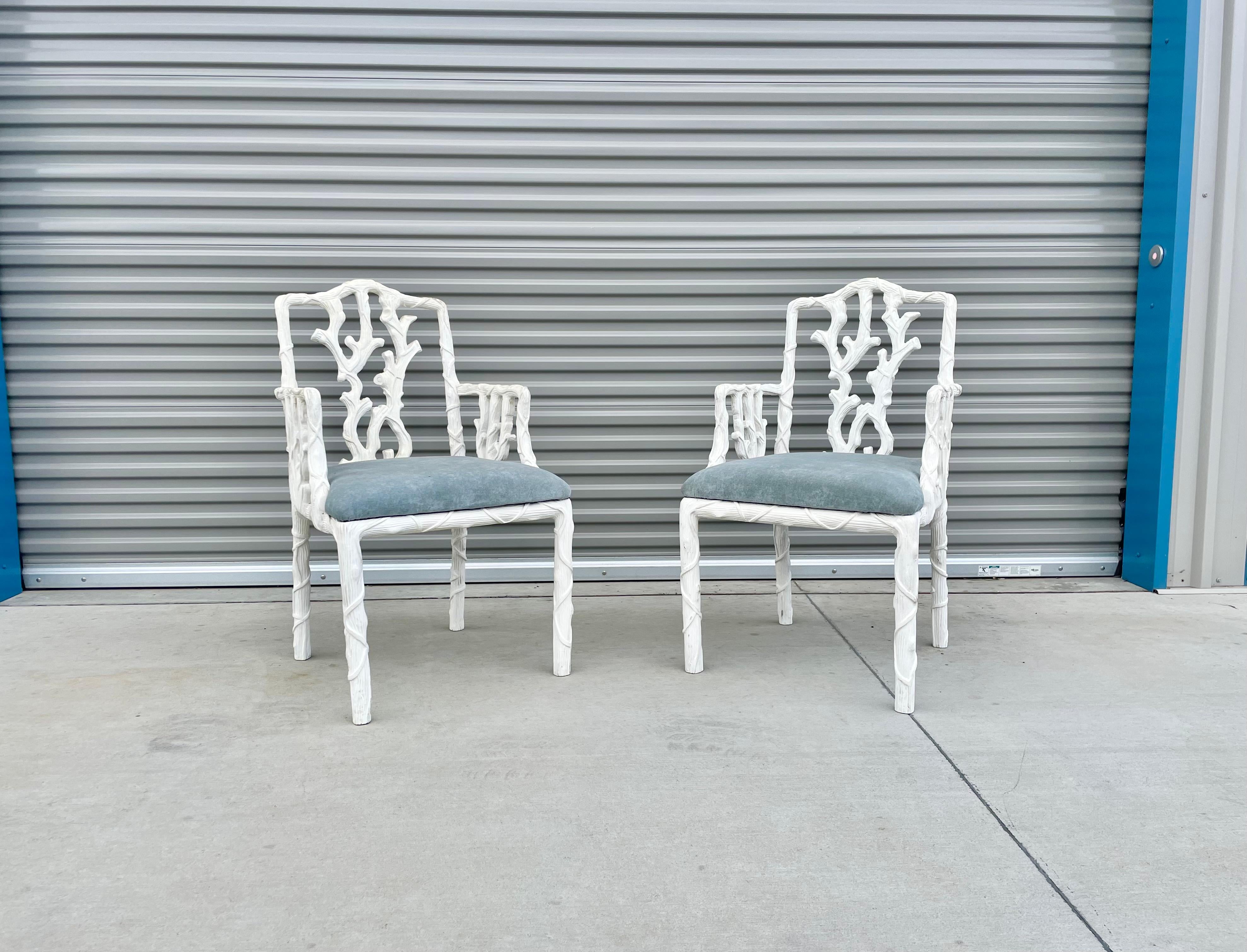 Vintage pair of armchairs designed and manufactured in France circa 1950s. These beautiful lounge chairs feature a wood base covered in a white lacquer paint. The chairs also feature a unique sculpture wood design that covers the backrest and