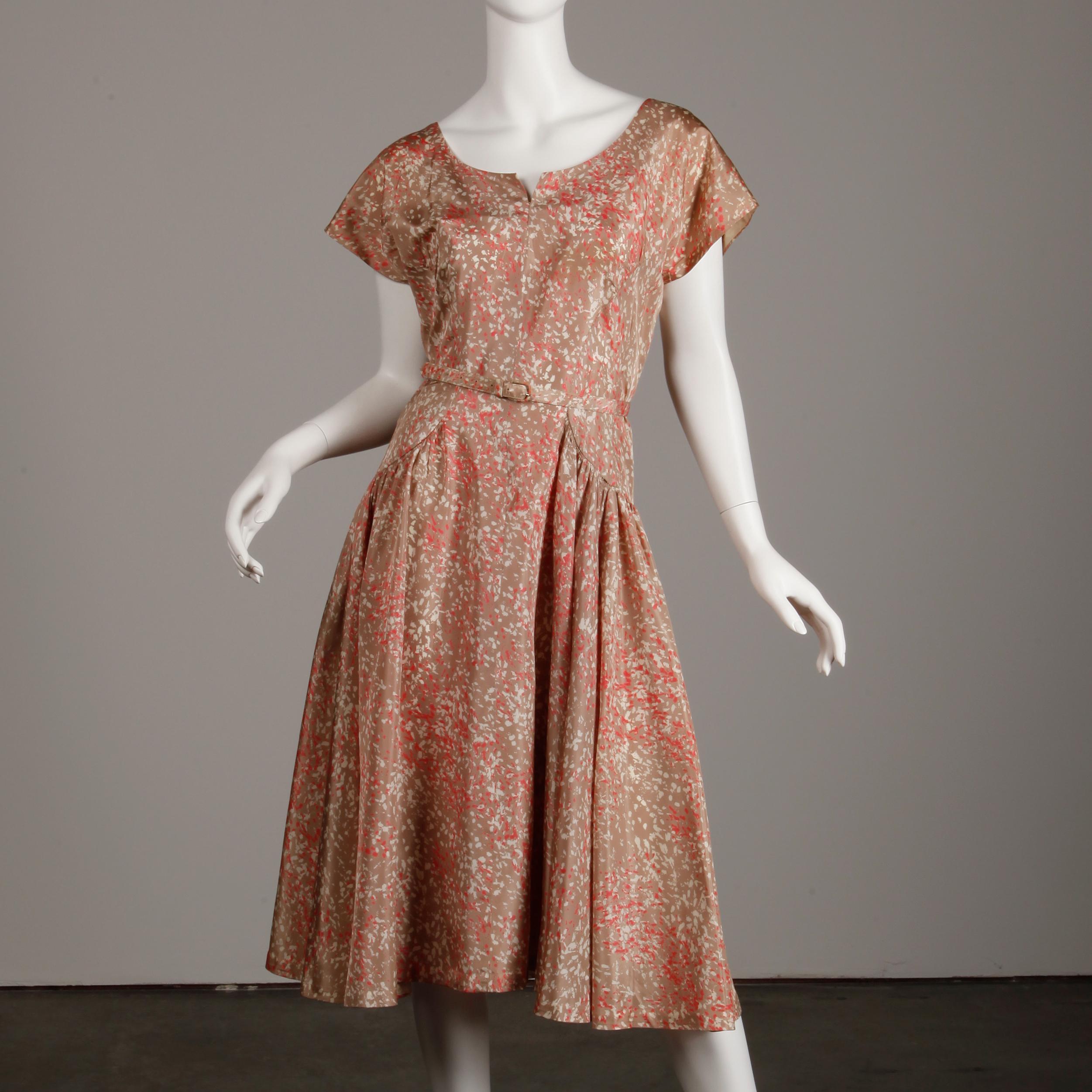Rare 1950s size large! This vintage ensemble comes with a dress, coat and matching belt in a fantastic mid century print done in pink, beige and mauve. The dress is unlined with rear metal zip and hook closure. The dress bust measures 38
