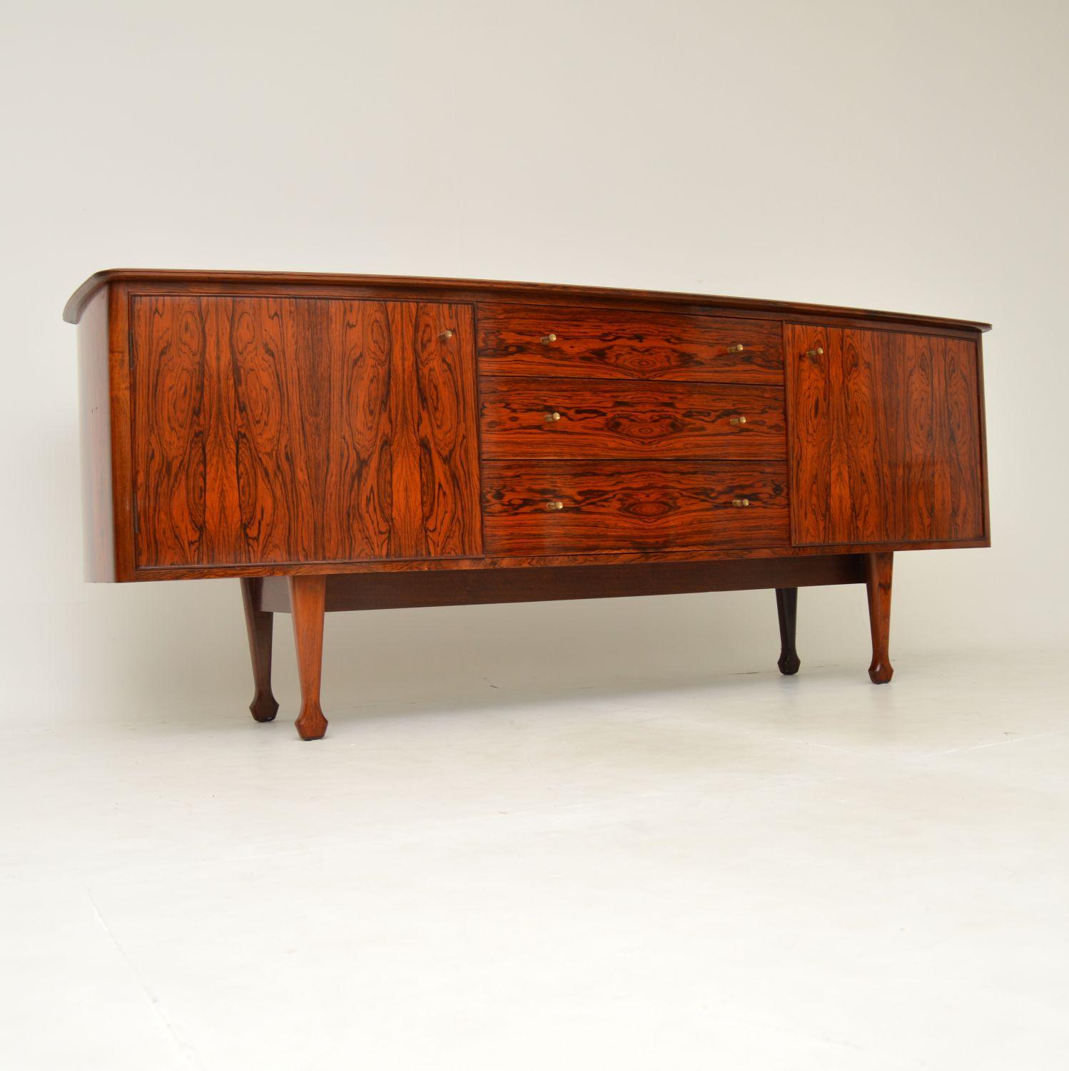A stunning and very rare vintage sideboard. This was designed by Andrew Milne and was manufactured in England by Heal’s, it dates from the early 1950’s.

This is of superb quality, with gorgeous grain patterns throughout, even on the inside. The