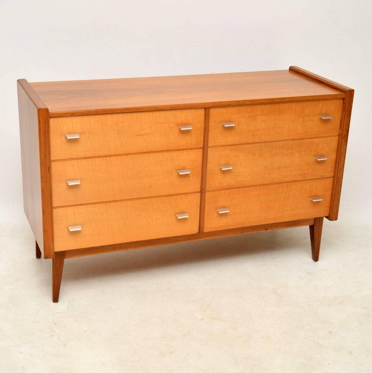 A beautiful and top quality vintage sideboard by the high end British manufacturer Alfred COX. This has a walnut carcass with sycamore drawers fronts. It’s extremely well made and is very heavy, with lots of storage space in the six drawers. The
